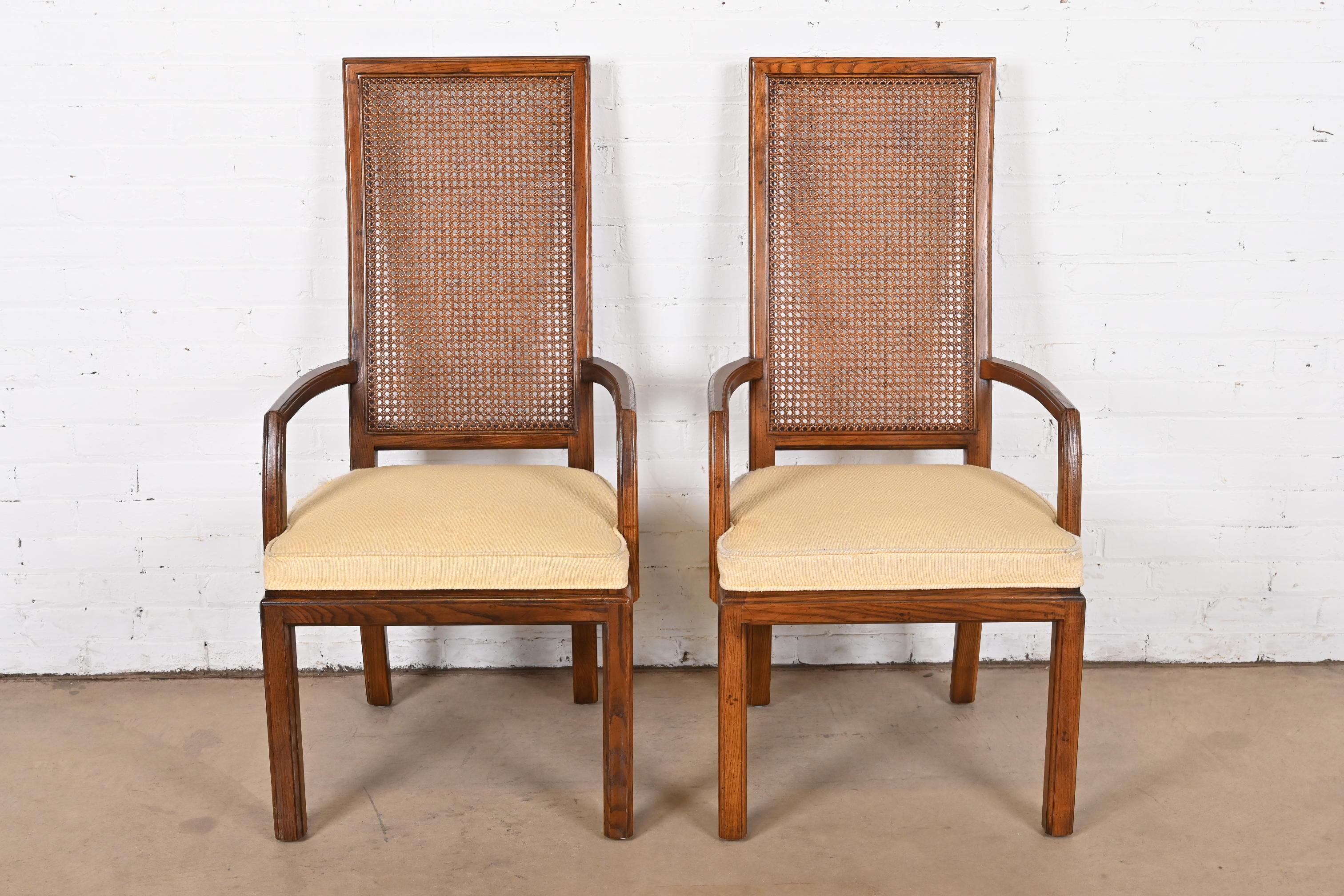 Magnifique paire de fauteuils de salle à manger à haut dossier de style moderne du milieu du siècle dernier.

Par Henredon

USA, Circa 1970s

Piétements en chêne, dossiers en rotin et sièges rembourrés.

Dimensions : 22 