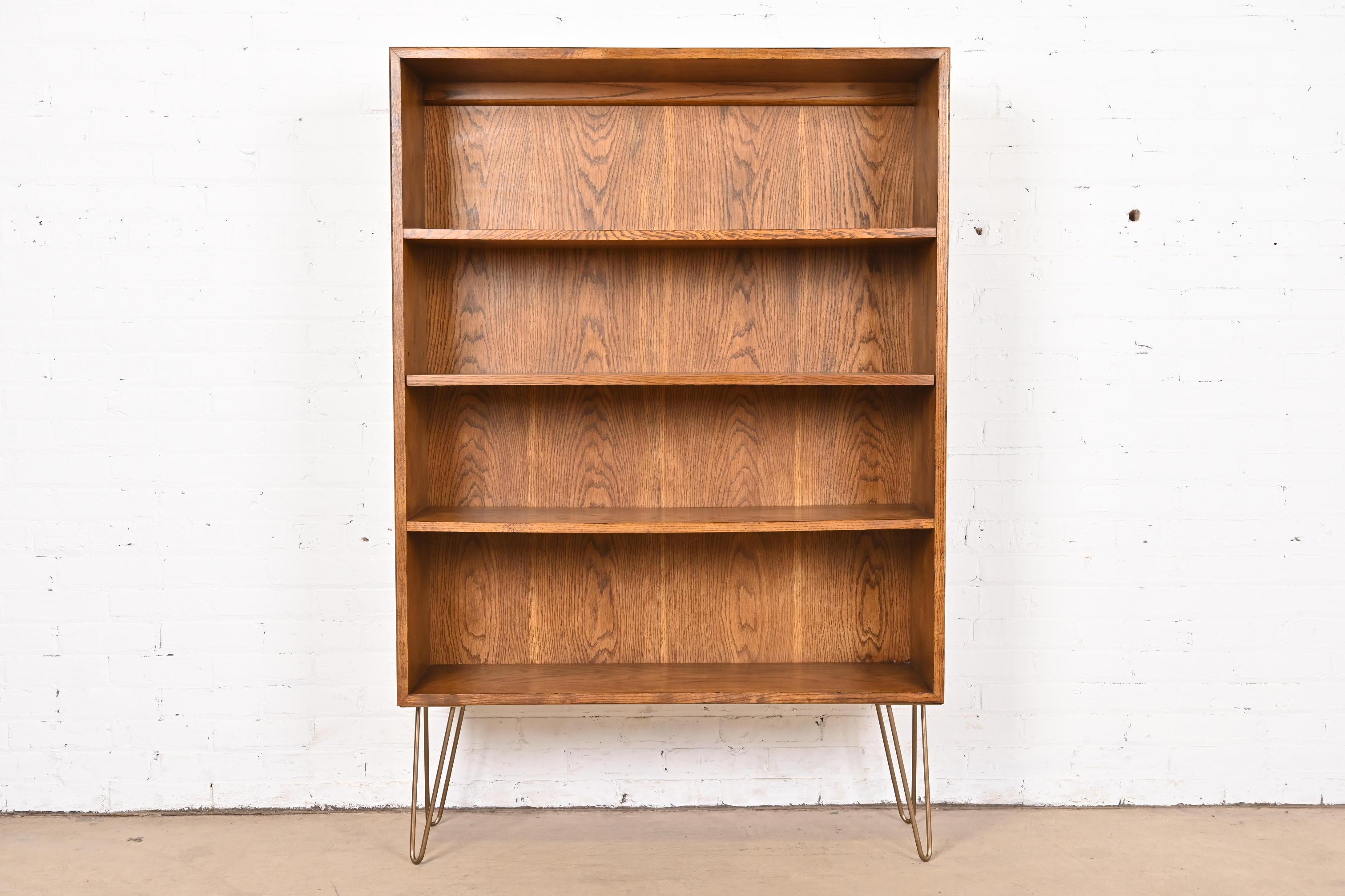 A gorgeous Mid-Century Modern oak bookcase

By Henredon

USA, Circa 1970s

Oak case, with brass finished steel hairpin legs.

Measures: 40