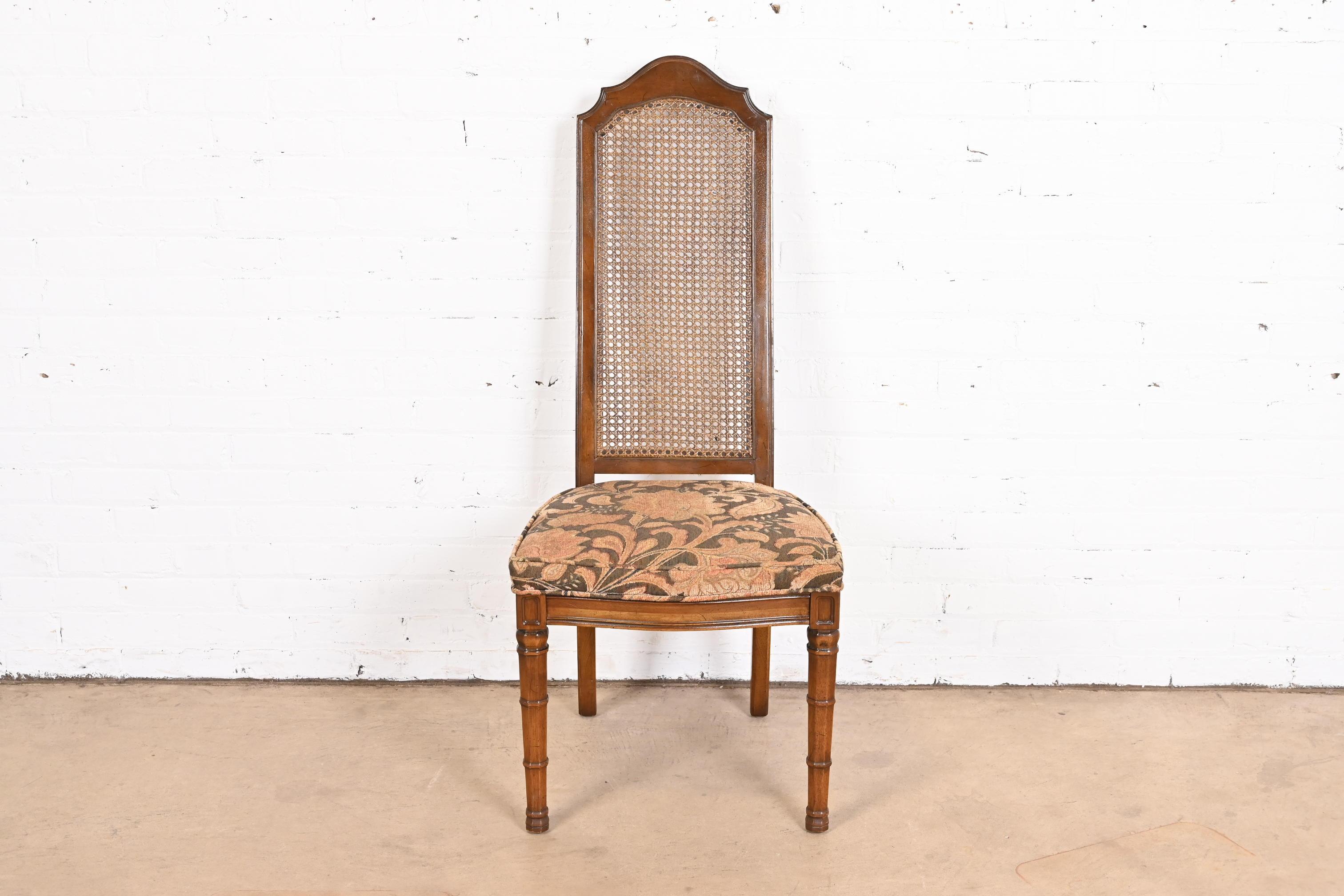 A gorgeous Mid-Century Modern Mediterranean style dining chair or side chair

By Henredon

USA, Circa 1970s

Sculpted walnut frame, with caned seat back and upholstered seat.

Measures: 20
