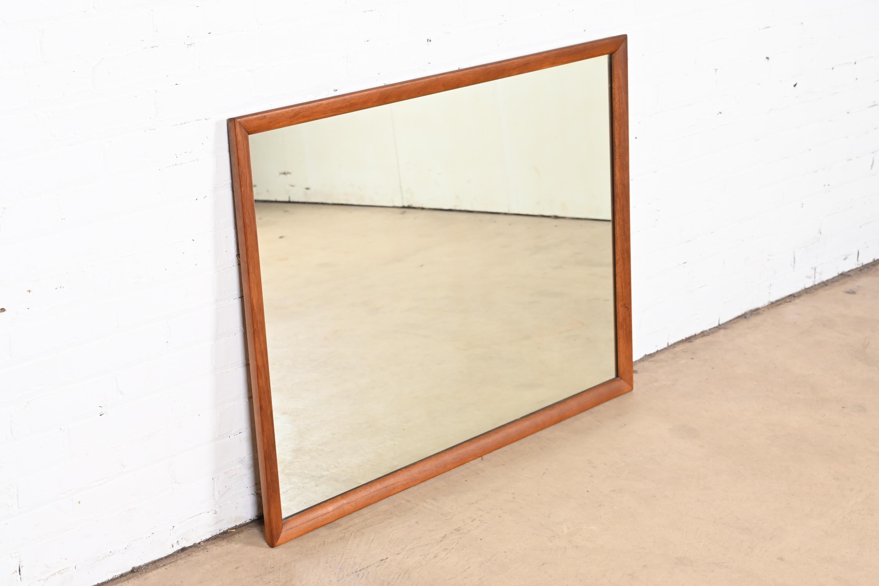 A stylish Mid-Century Modern sculpted walnut framed wall mirror

By Henredon

USA, 1960s

Measures: 42.38