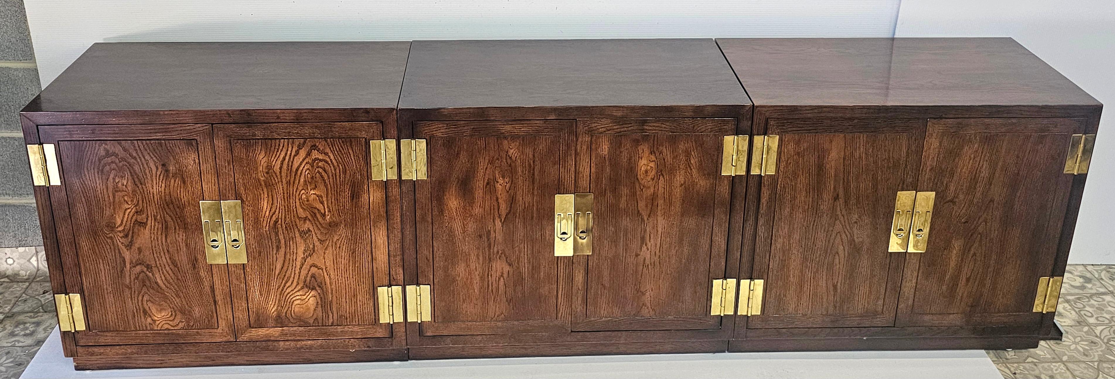 A Stunning high quality vintage three-part Henredon campaign credenza sideboard. Post mid century, circa 70s. Solid wood with select grain all around. Antiqued Brass cast brass hardware. Adjustable shelf in each piece. Each individual piece is 32