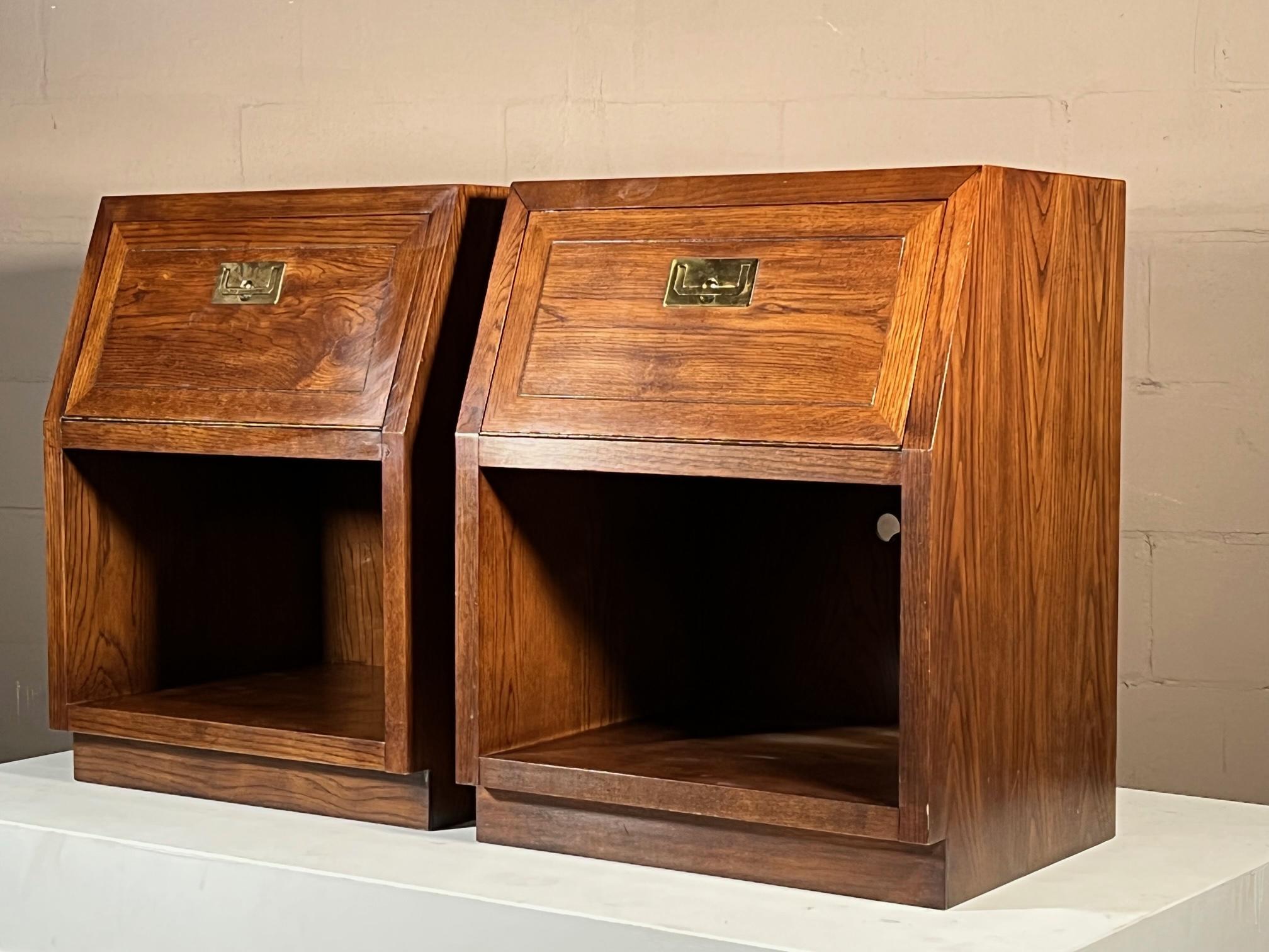 A pair of unusual night stands by Henredon. Drop down front drawers, brass campaign style hardware. Bottoms of open cases are lighted and have small cutouts in the back.