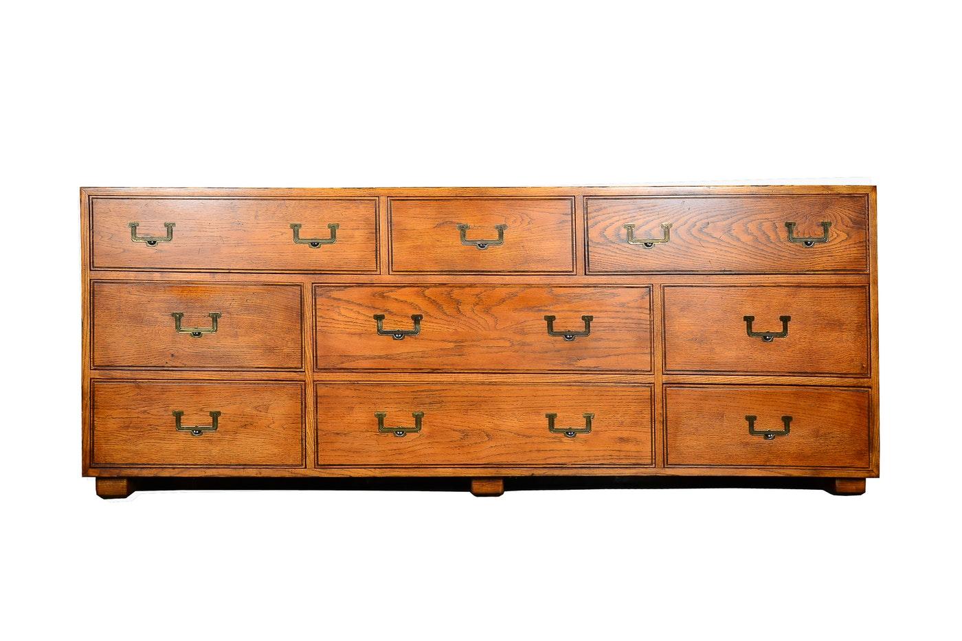 A beautiful oak Campaign style dresser by Henredon as part of their Artefacts collection. It features nine dovetailed drawers, original brass hardware, recessed handles and a divided centre drawer. Great construction and style.