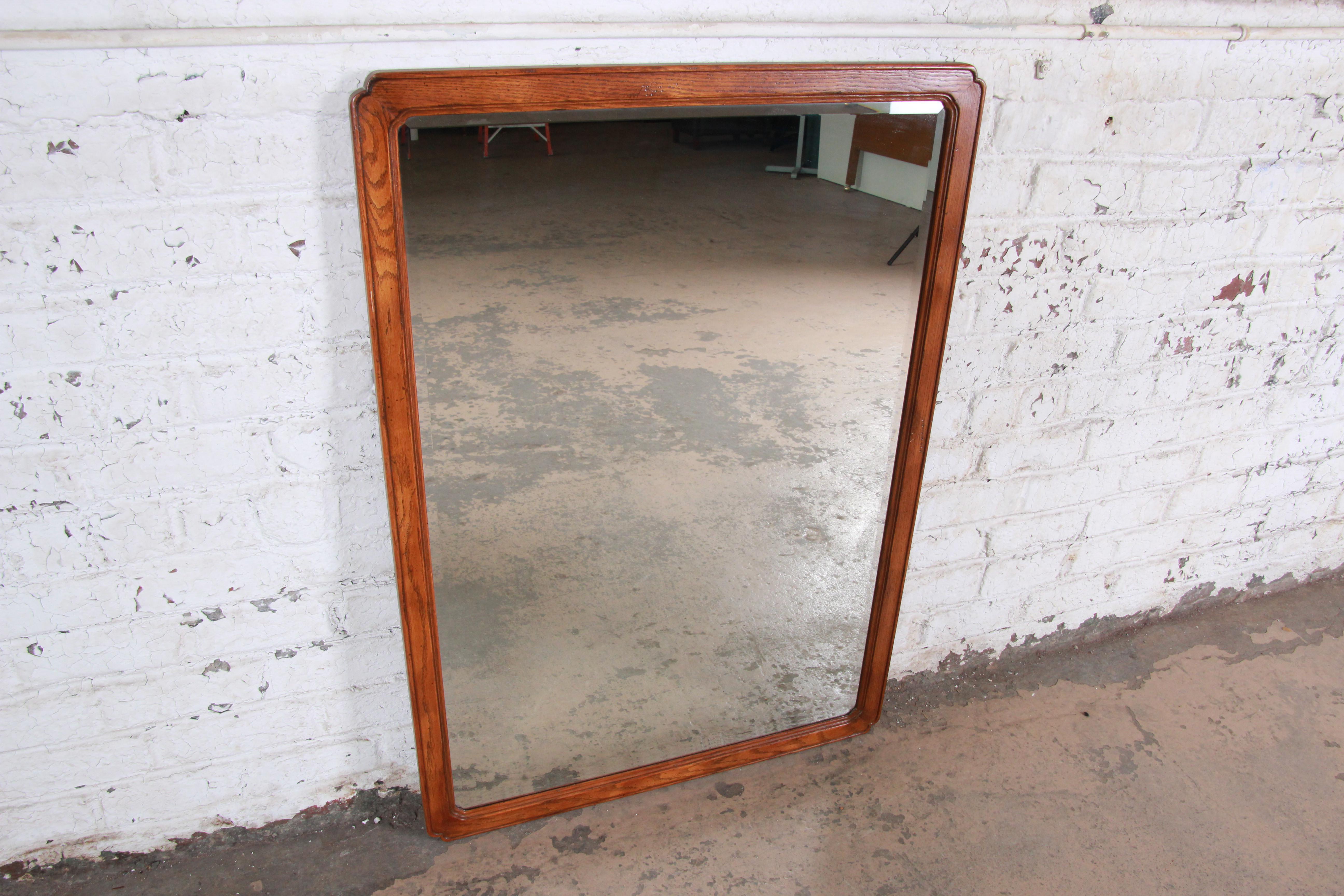 A nice oak beveled mirror by Henredon. The mirror has a clear reflection and nice oak frame. The frame has nice rounded edges and is in excellent vintage condition.