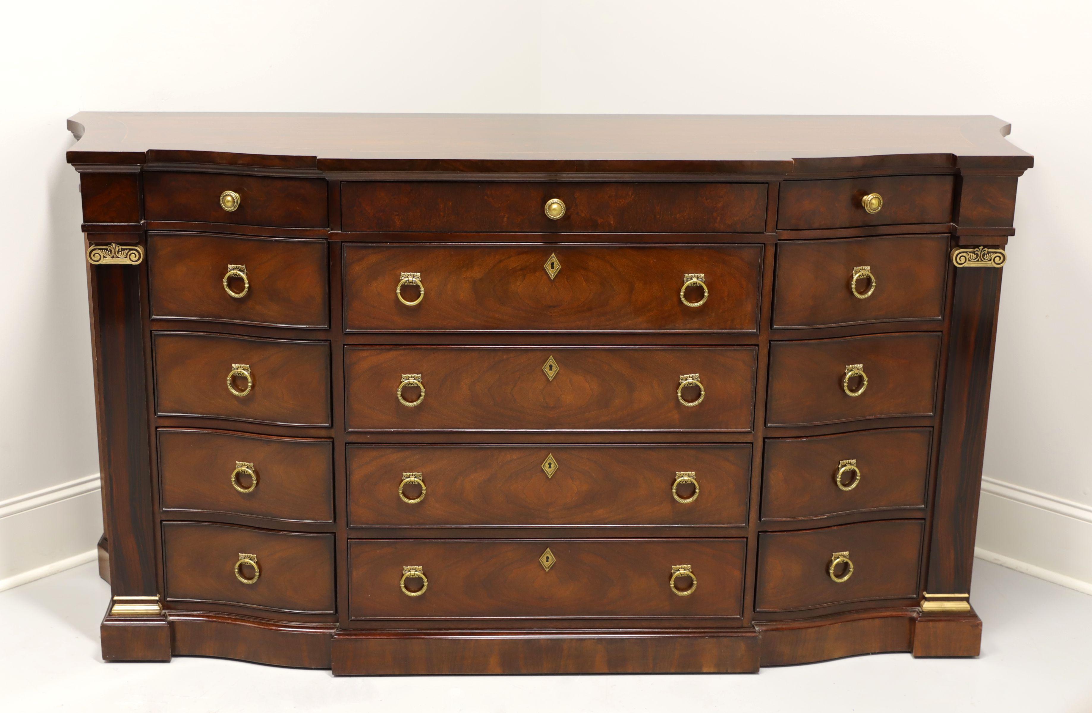 A monumentally sized, Regency style, dresser by Henredon. Mahogany and veneers with brass hardware, banded top, columned sides with gold painted caps and a serpentine front. Features fifteen various size drawers with faux lockplates on four center