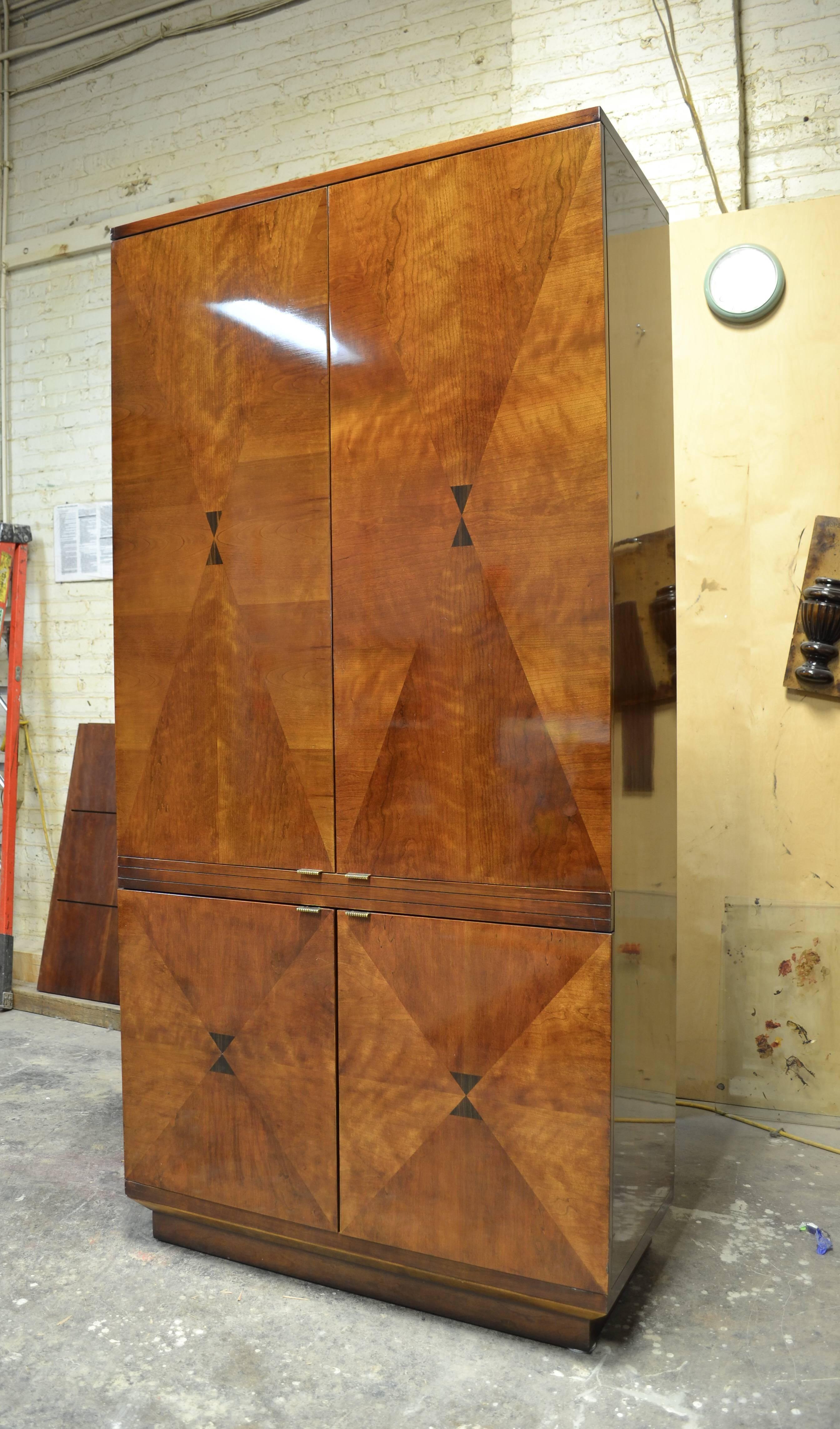 This vintage cabinet is one of our favourite old Henredon designs. The patina of the cabinet has softened to a mellow color which highlight its decorative veneer. The cabinet has drawers in the lower part, and was originally designed for television