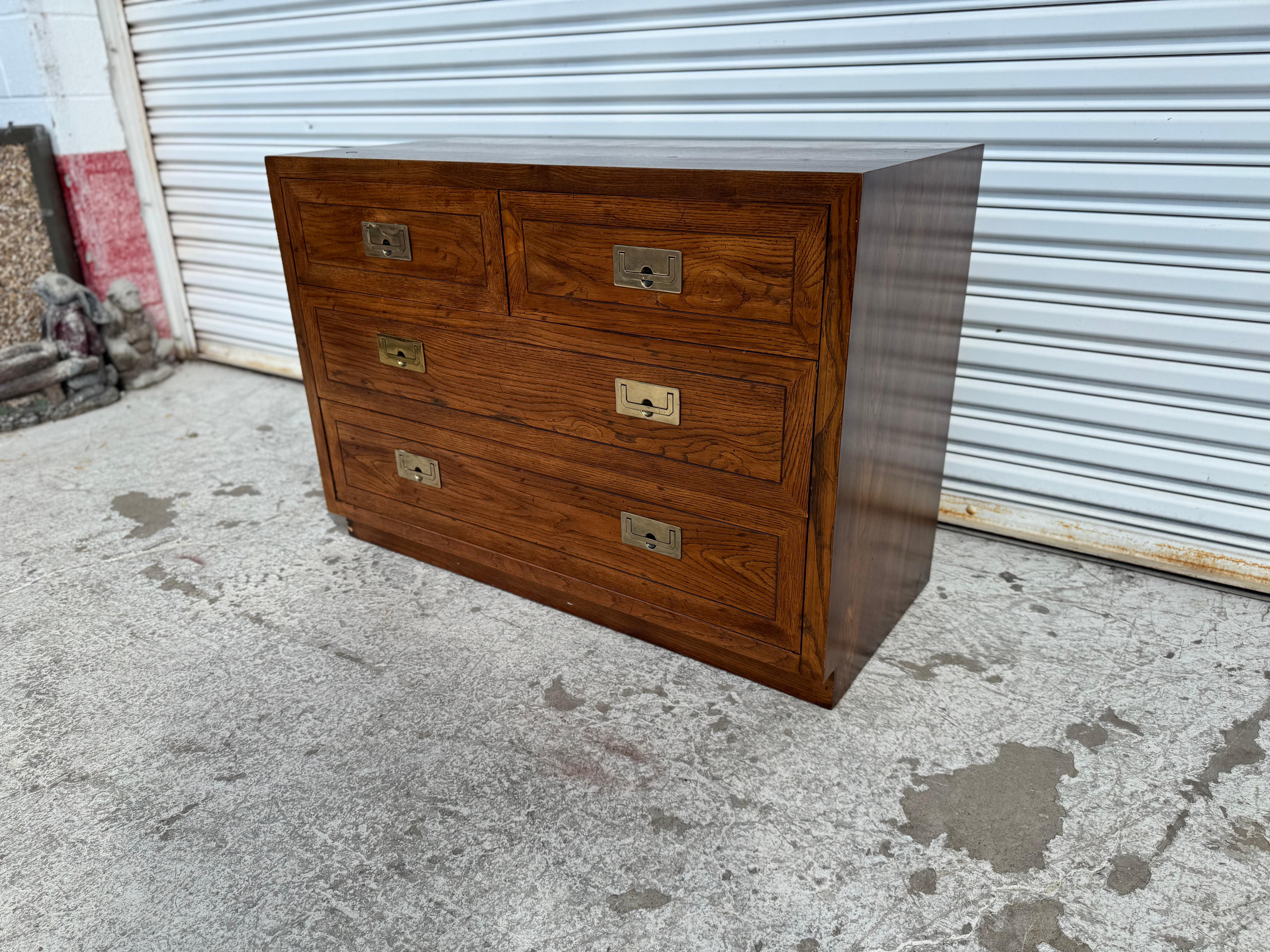 Cette commode de style Campaigner est fabriquée par Henredon Furniture.
La commode est en noyer et possède des tirettes de campagne en laiton.
Il comporte 4 tiroirs pour un grand espace de rangement et repose sur un socle.
