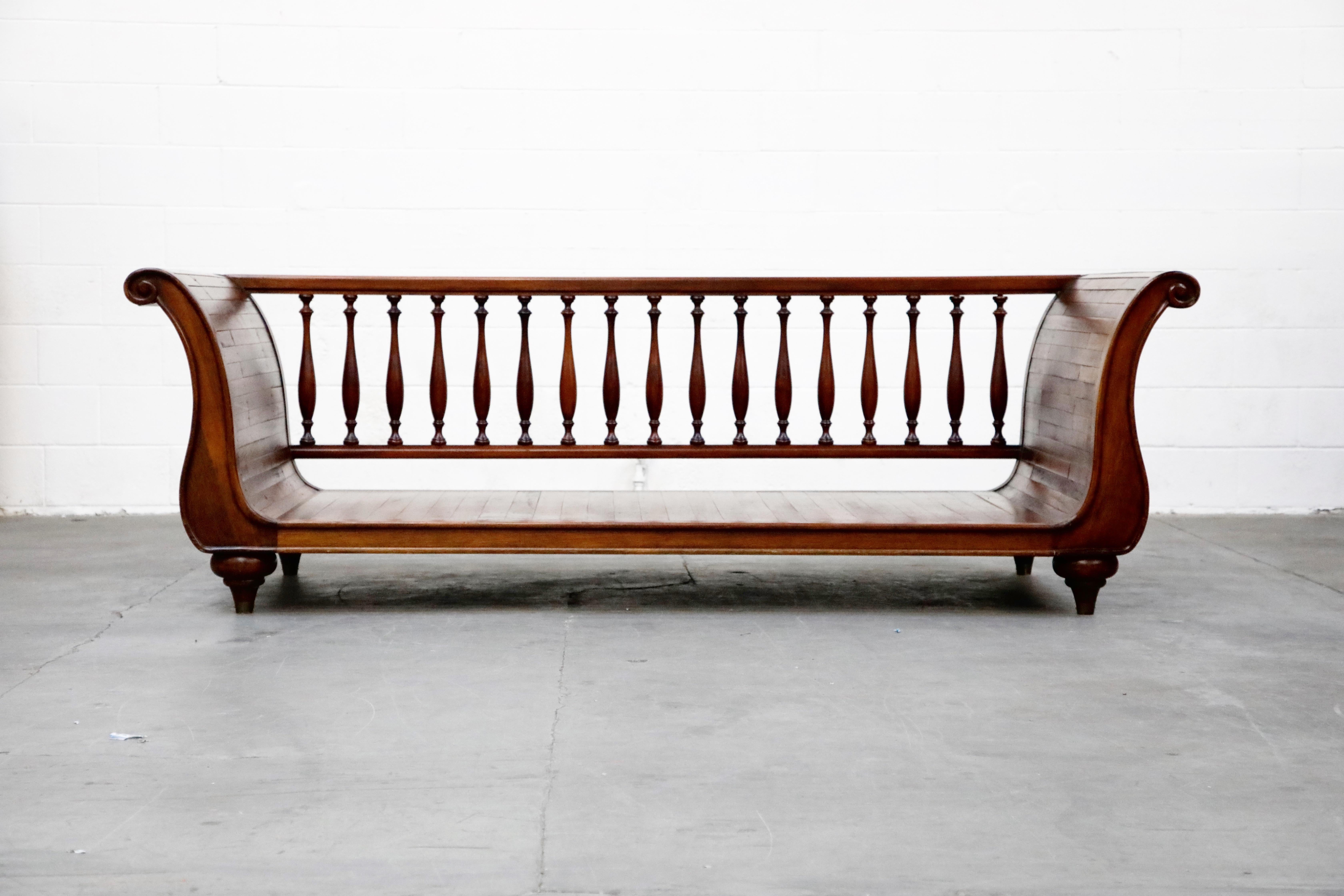 An incredible high quality wood daybed in sleigh form by Henredon. This designer piece features a spindle rail back with 17 turned wood spindles, turned wood bun legs / feet, and strips of wood planks assembled in a sleigh form with rolled arms.