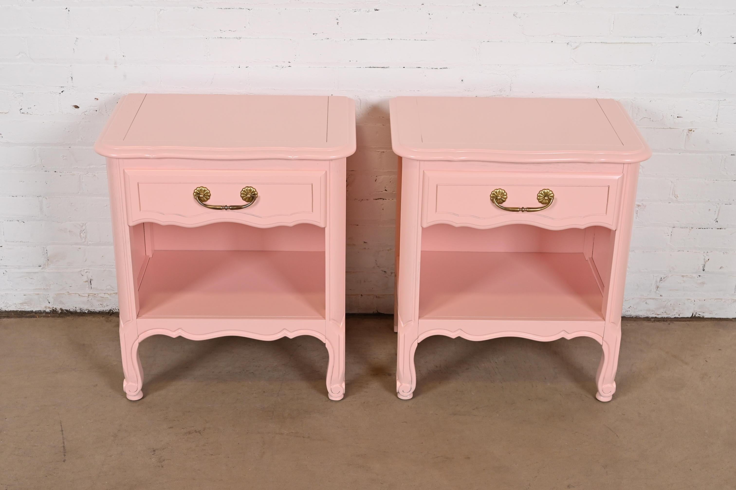 A gorgeous pair of French Provincial Louis XV style nightstands or bedside tables

In the manner of Henredon

USA, Circa 1960s

Pink lacquered wood, with original brass hardware.

Measures: 21.75