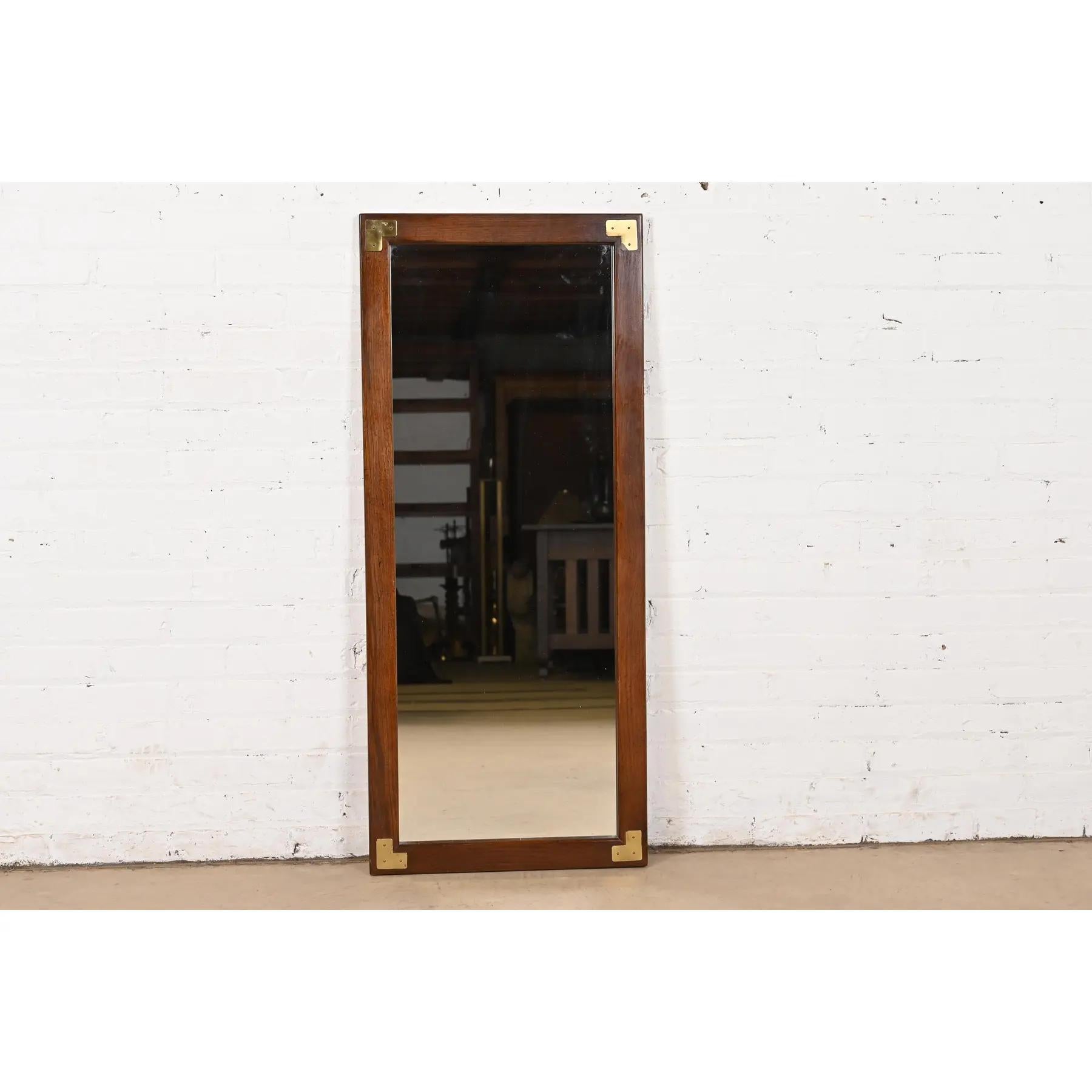 A stylish pair of Mid-Century Modern Hollywood Regency Campaign style oak and brass framed wall mirrors

In the manner of Henredon

USA, Circa 1970s

Measures: 19.5