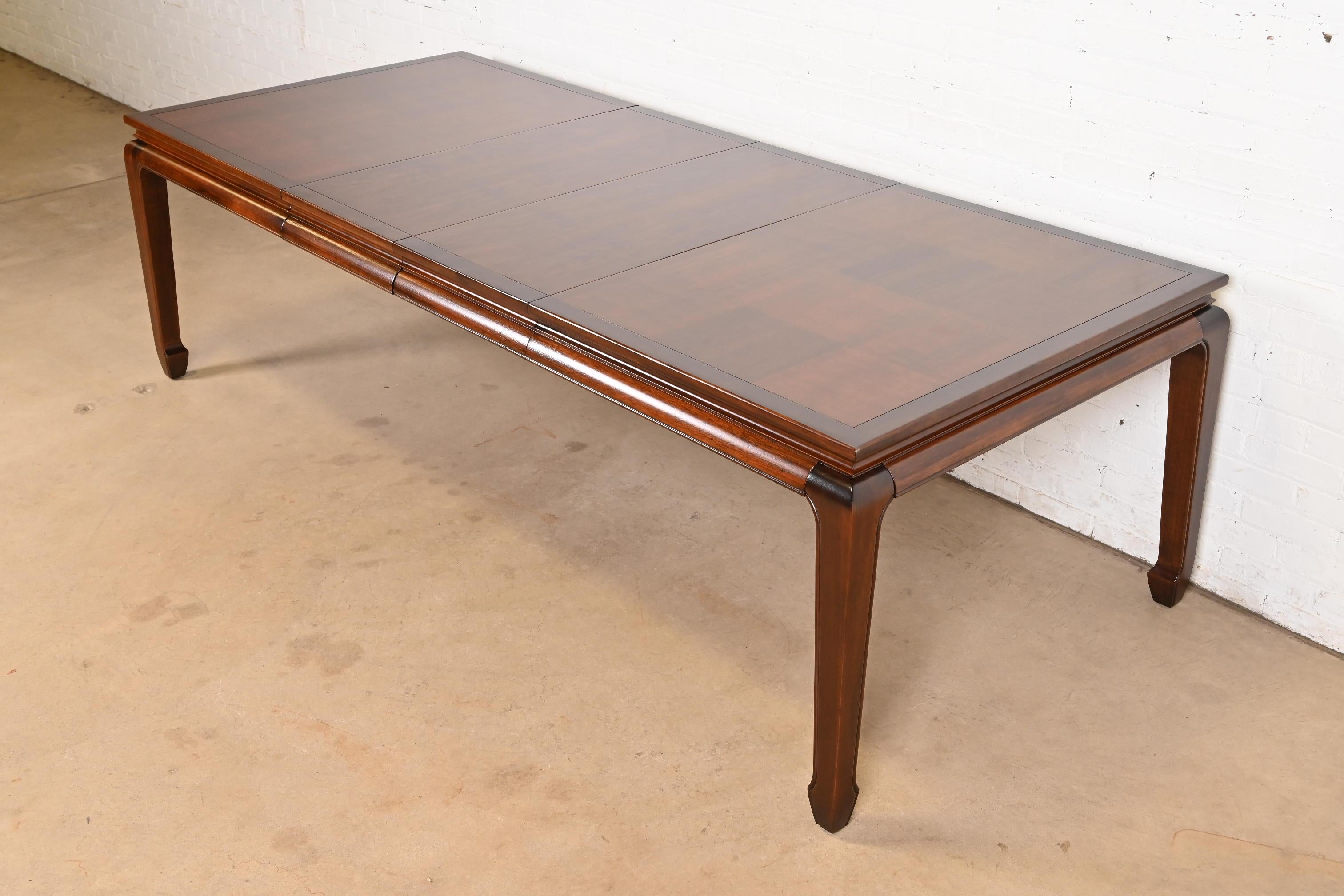 Uno splendido tavolo da pranzo allungabile in stile Hollywood Regency Chinoiserie della metà del secolo scorso

Alla maniera di Henredon

USA, circa anni '1970

Noce intagliato, con un bellissimo piano in parquet patchwork.

Misure: 65 