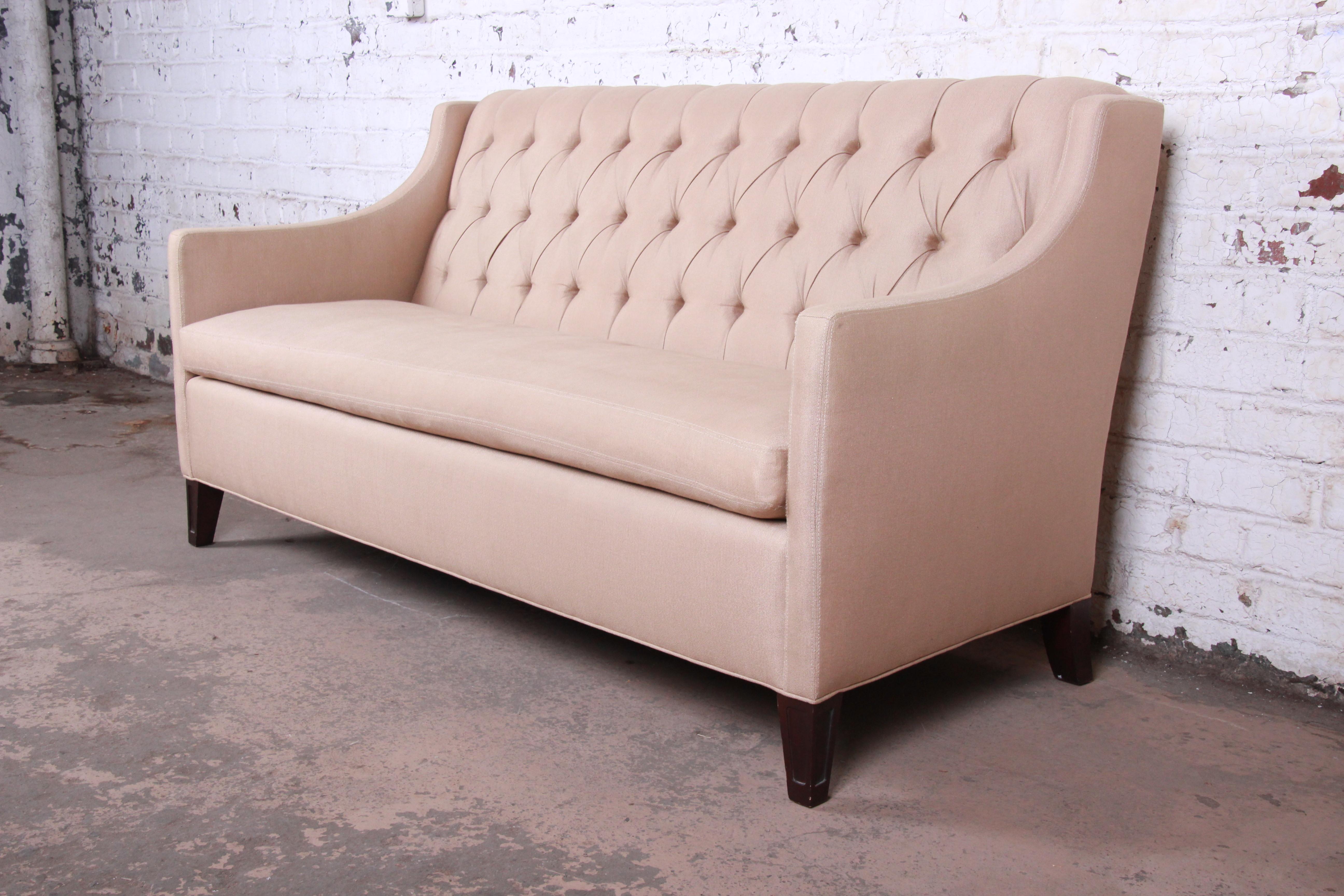A gorgeous modern tufted sofa with tan upholstery

By Henredon 