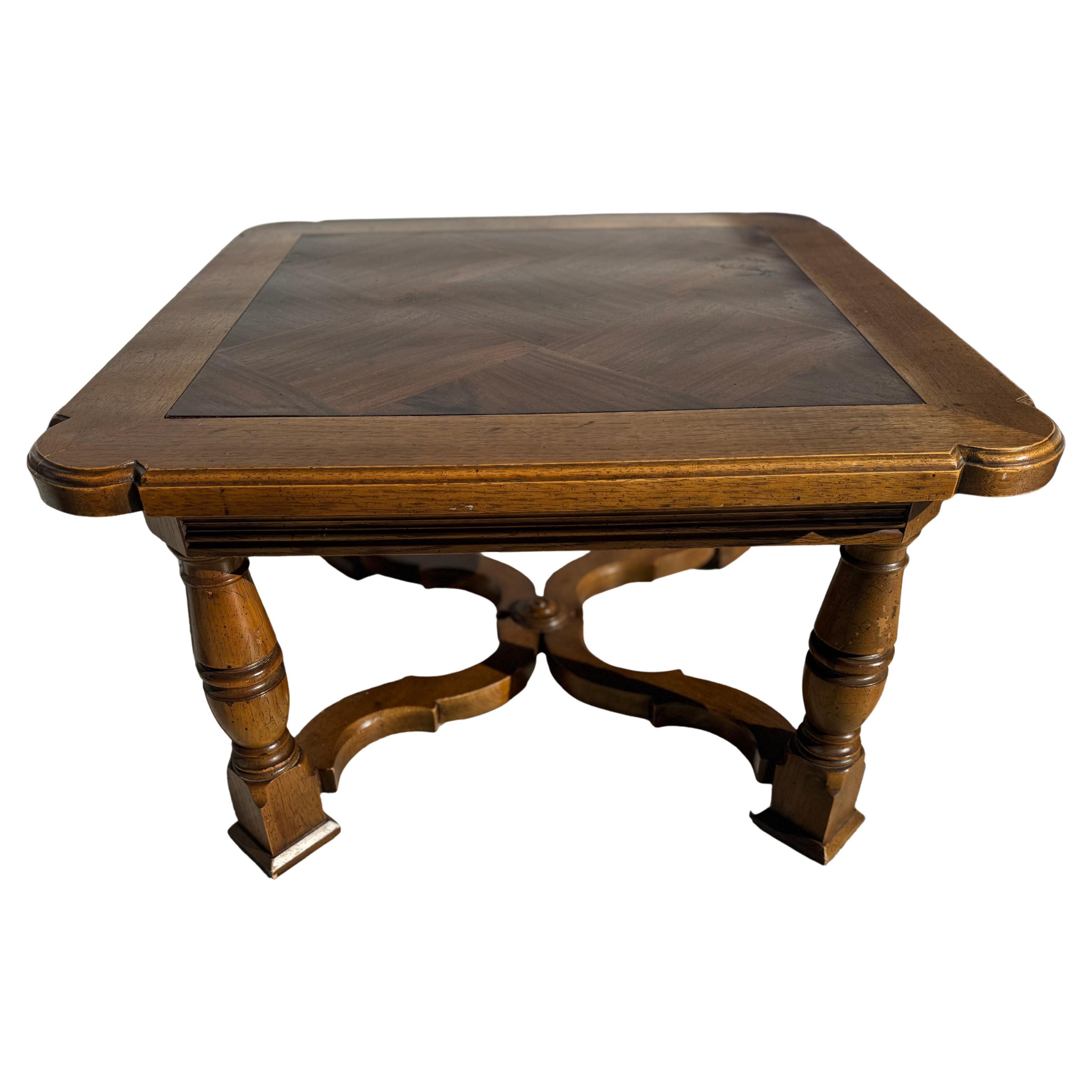 This is a finely crafted piece of furniture by Henredon Furniture.
The piece was made in a Tudor style.
It's made of walnut and has a parquet styled top.
The table has an x-base stretcher for assured stability.
