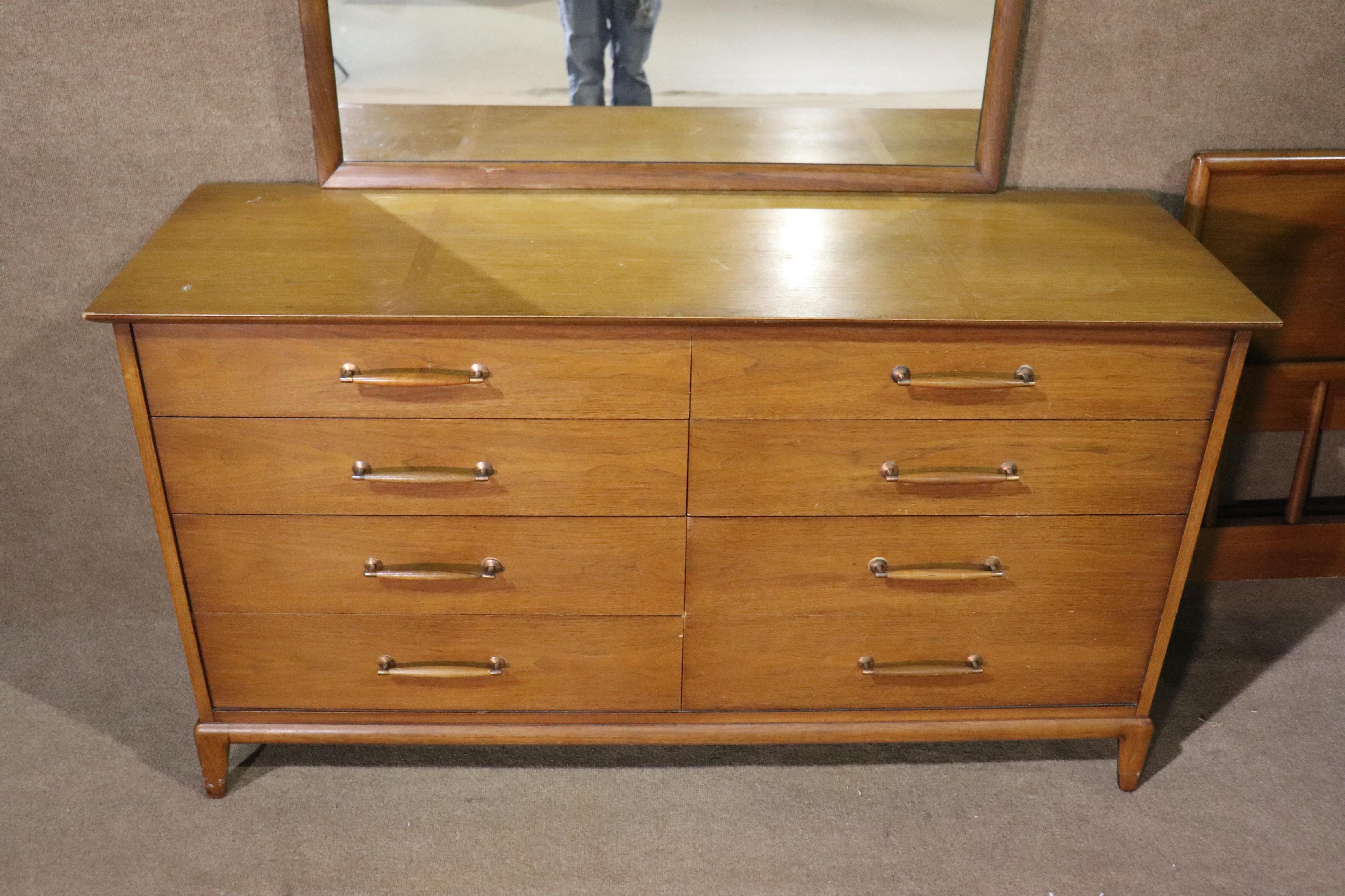 Long mid-century dresser and mirror by Henredon. Walnut wood inlay strips on top, wood sculpted handles, tapered leg base.
* Matching pieces available *
Please confirm location NY or NJ