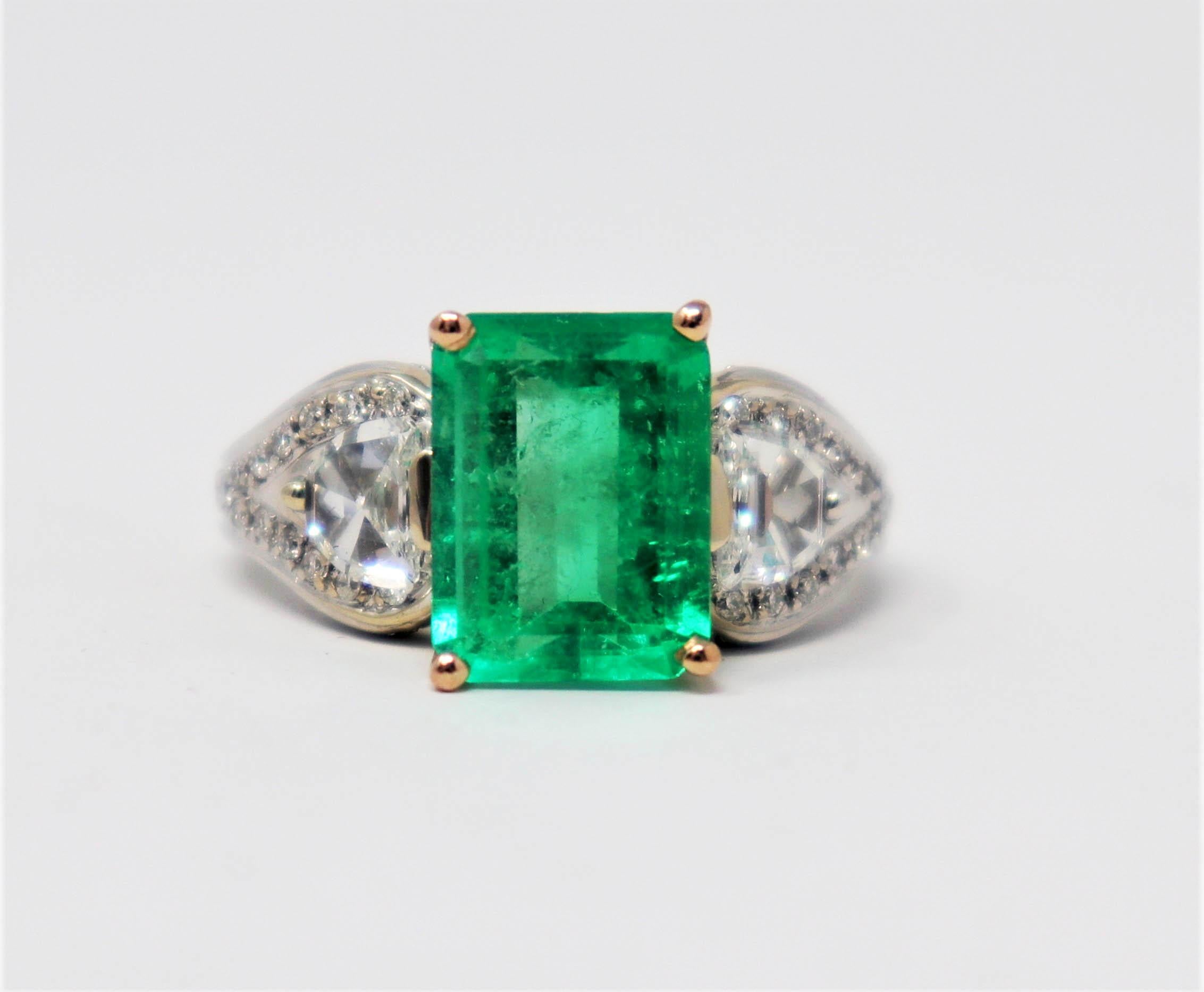 Taille de l'anneau : 6.75

Spectaculaire bague à trois pierres en émeraude naturelle et diamant conçue par Henri Daussi. La brillante pierre émeraude vert vif se détache magnifiquement sur les diamants blancs éclatants et attire vraiment l'attention
