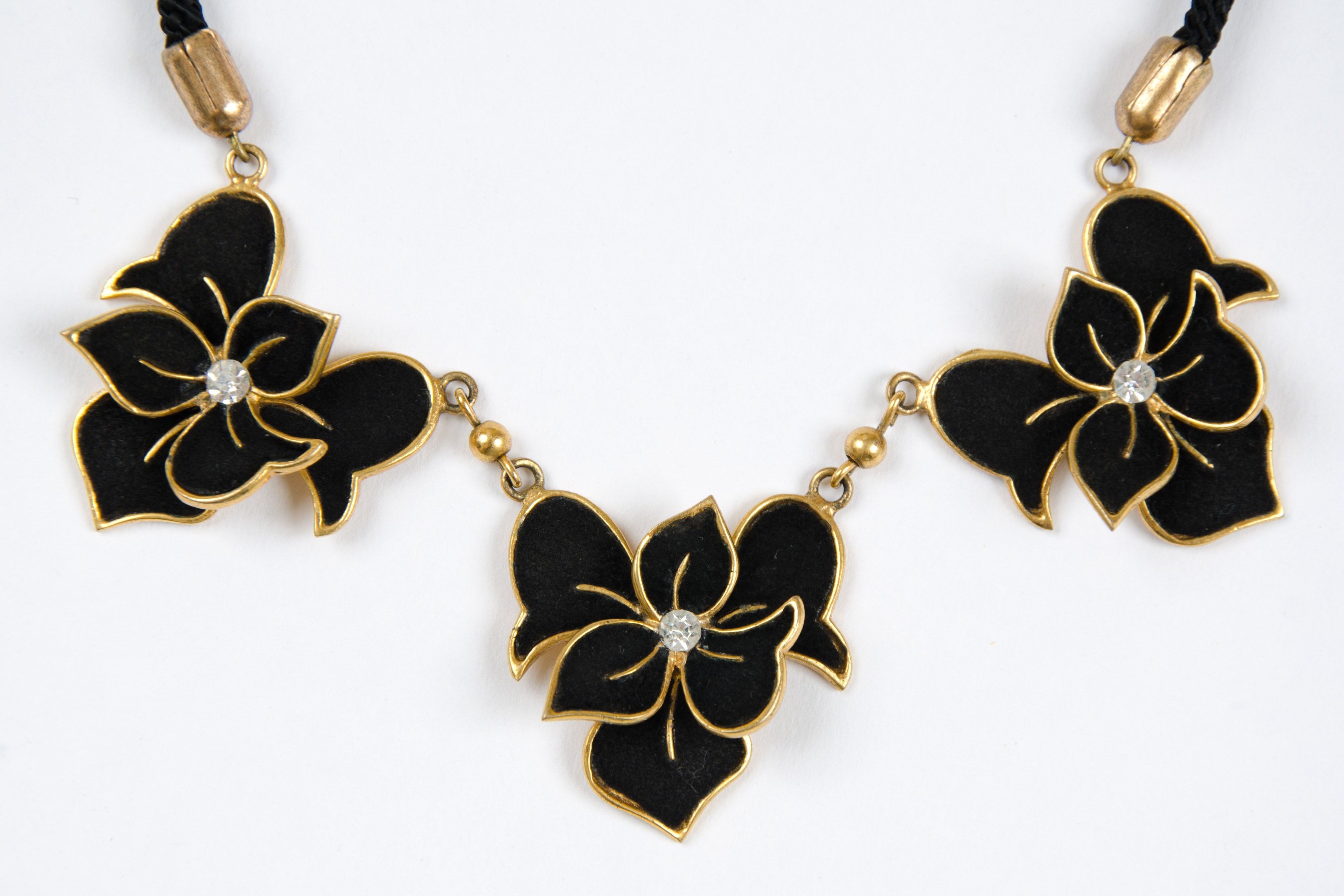 Am immaculate and charming suede and gilt metal necklace with paste highlights. A classic example of this brand, whose pieces are rarely found, particularly in this condition. 
Starting with two shops in Paris in the early 1920s, Henry de la Pensee