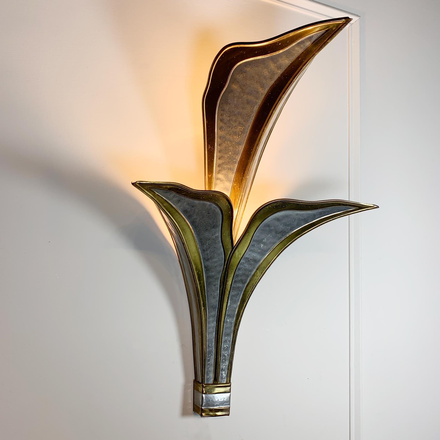 Stunning hand crafted wall light, made from brass and chrome by the renowned French artist and sculptor Henri Fernandez, it is formed as a geometric two tiered leaf, and dates to the 1980’s.

Measures: Height 48cm, Width 32cm, Depth 23cm.

