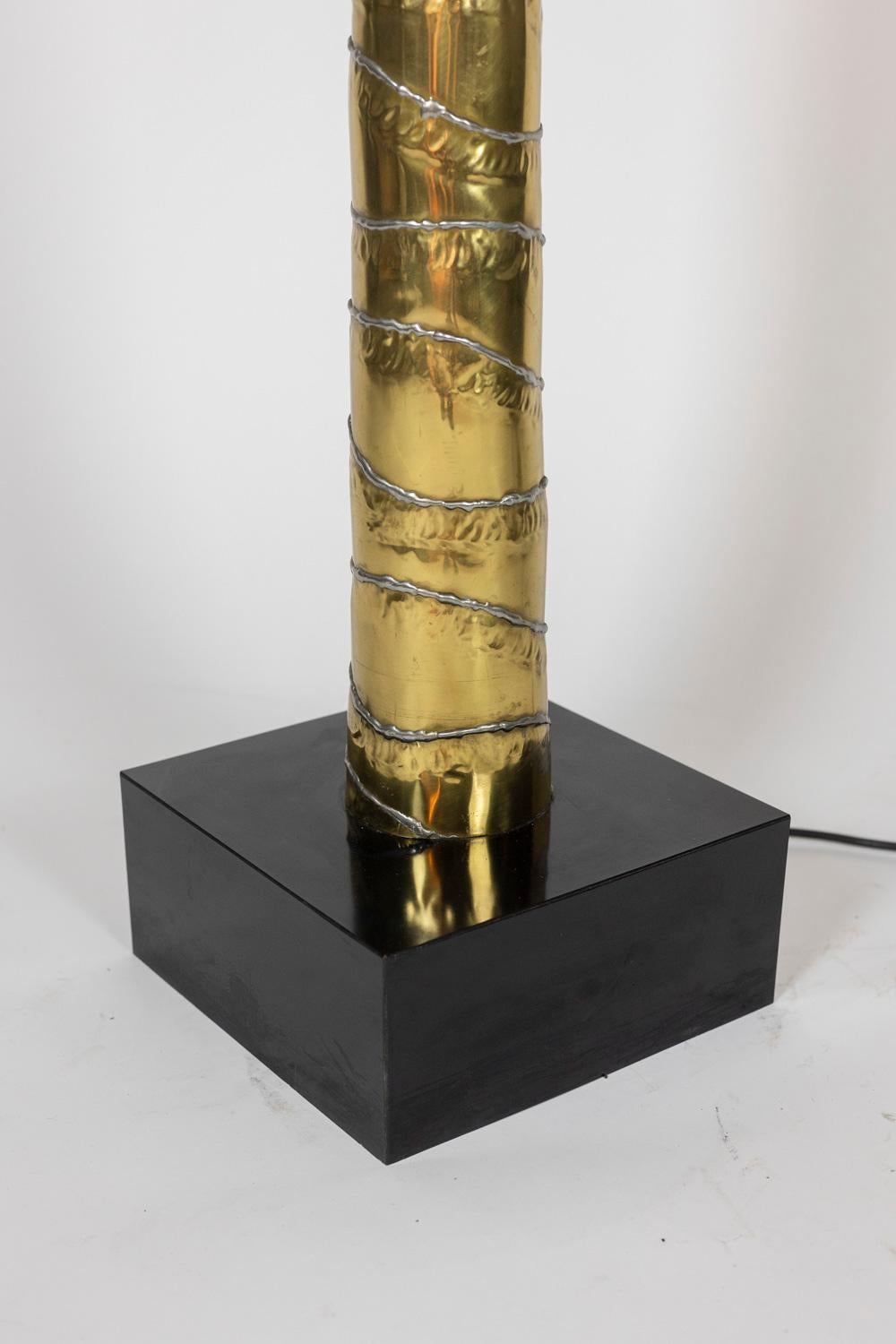 Henri Fernandez, by.
Maison Honoré, edited by.

Floor lamp in gold and silver brass, representing a palm tree, ending in a black lacquered wooden base with a square shape.

French work realized in the 1970s.

Possibility of forming a “pair” with