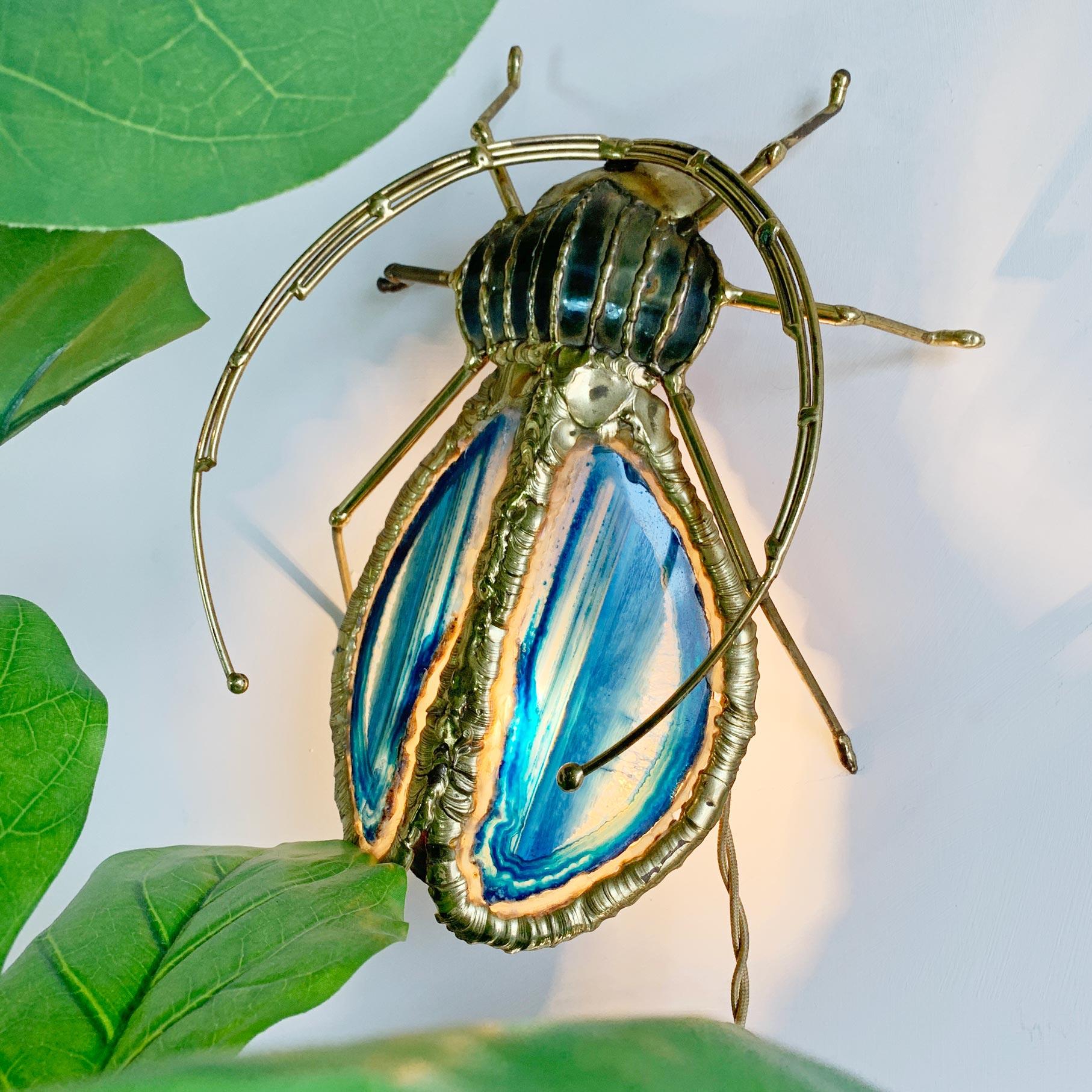 Rarissima scultura in ottone e agata di Henri Fernandez per l'Atelier Duval Brasseur, modellata come un coleottero Longhorn e risalente agli anni '70.

Le bellissime ali di agata blu sono incastonate nel grande corpo in ottone e illuminate dal basso