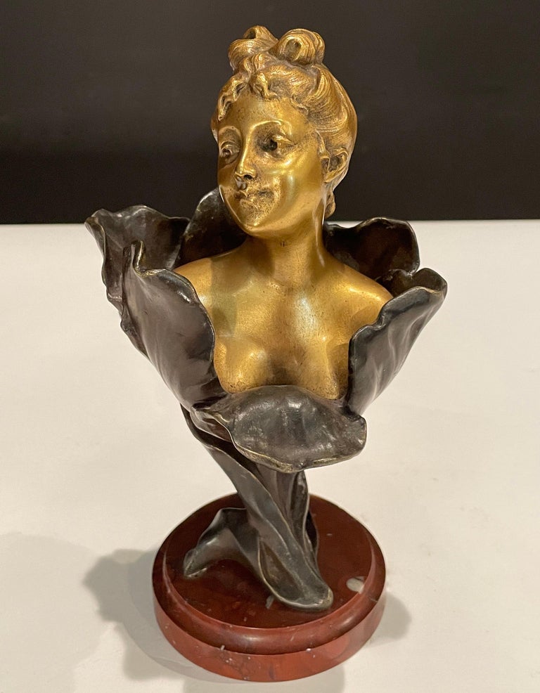 A fine unusual two tone gilt and patinated bronze bust of a young lady rising from the center of a tulip flower with fine detail, raised on a breche griotte circular marble plinth, signed H Godet & inscribed Med d'Or to represent that this subject