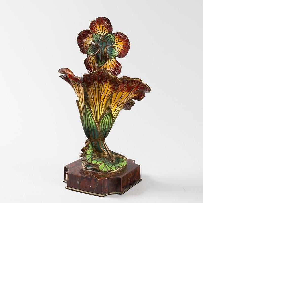 Une Femme Fleur en bronze émaillé de l'Art Nouveau français par Henri Godet (1863-1937).  La sculpture représente la tête et le cou en bronze patiné d'une jeune femme qui sort d'une fleur de lys émaillée rouge et jaune. Elle repose sur un socle en