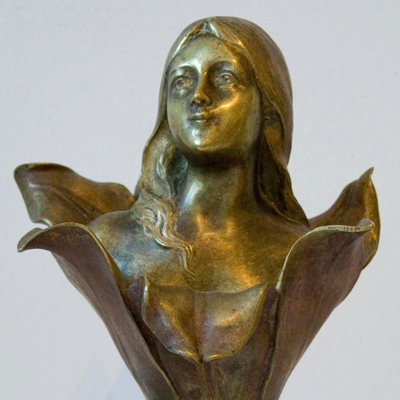 A very rare and elegant Art-Déco sculpture by Henri Godet, executed in bronze. It depicts a young woman's head coming out of a blossom. This masterpiece captivates the observer by the woman's smile which appears mischievous and at the same time