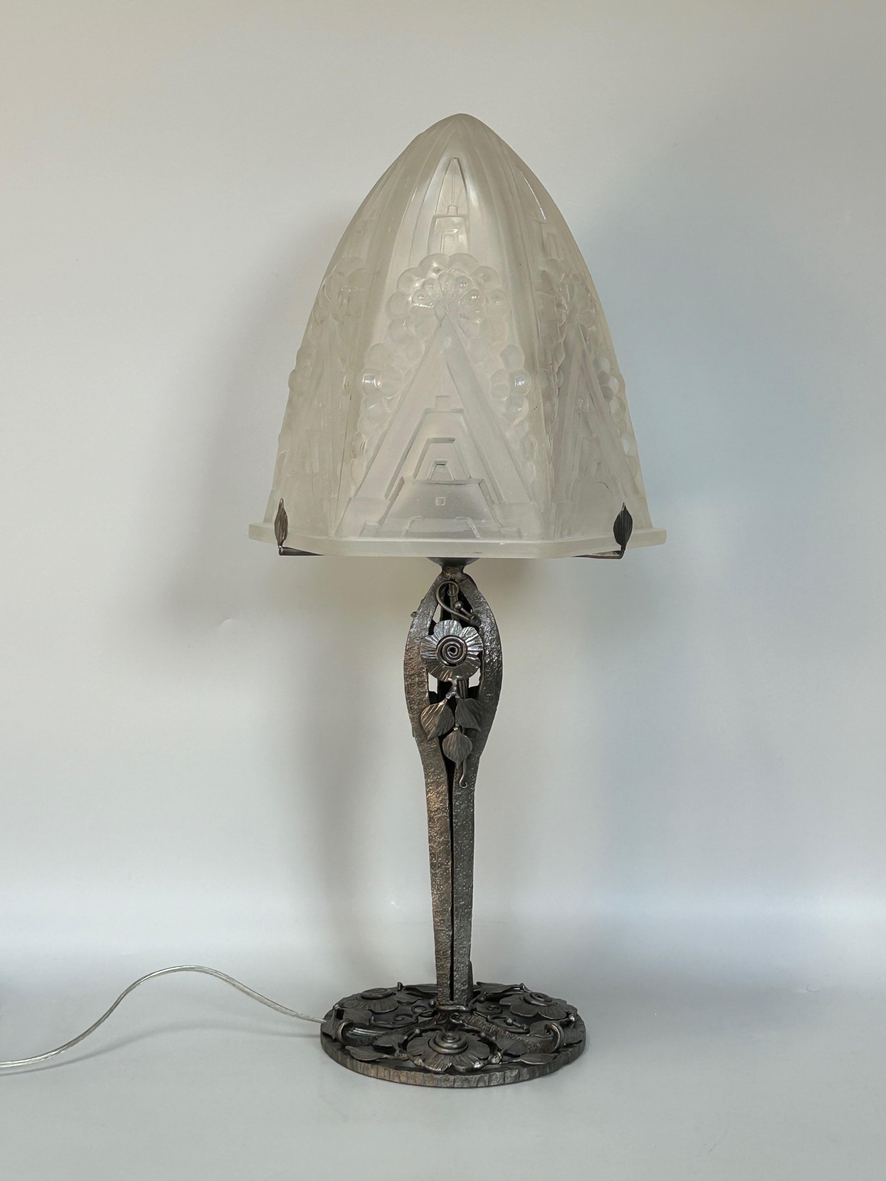 Henri Mouynet Art Deco Lamp

Art deco lamp circa 1930.
Nickel-plated wrought iron foot with floral decoration.
Molded glass shell, geometric and floral decoration.
Attributed to Henry Mouynet.
Electrified and in perfect condition.

Total height: