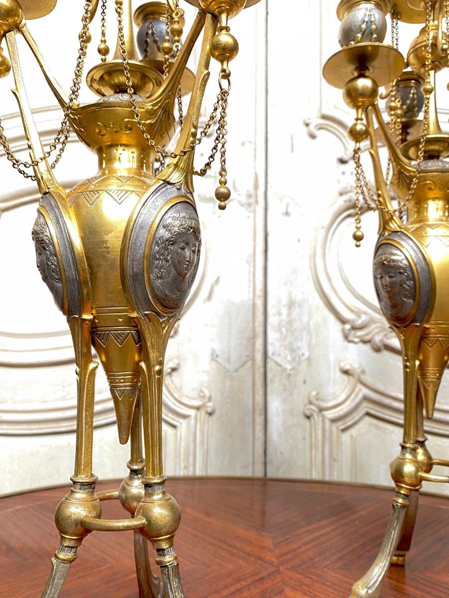 Pair of gilt bronze and silver bronze candelabra decorated with cherubs at the top and resting on feet in the form of hooves. They are decorated with bas-reliefs representing masks of women. Model by Henri Picard unsigned. Bronzier renowned under