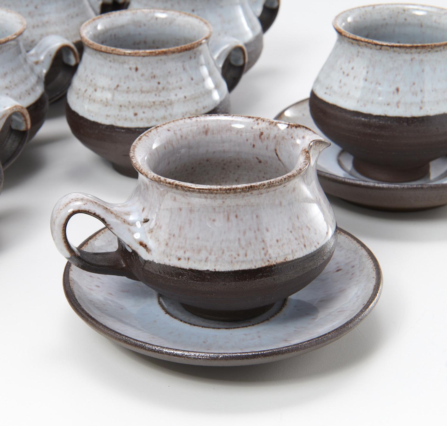 A remarkably intact set of 12 demitasse cups and 12 saucers (with creamers and sugar bowl) from renowned Danish potter, Henrik Ditlev Larsen. Ditlev was a very skilled potter and his work is both elegant and simple. These pieces have a lovely