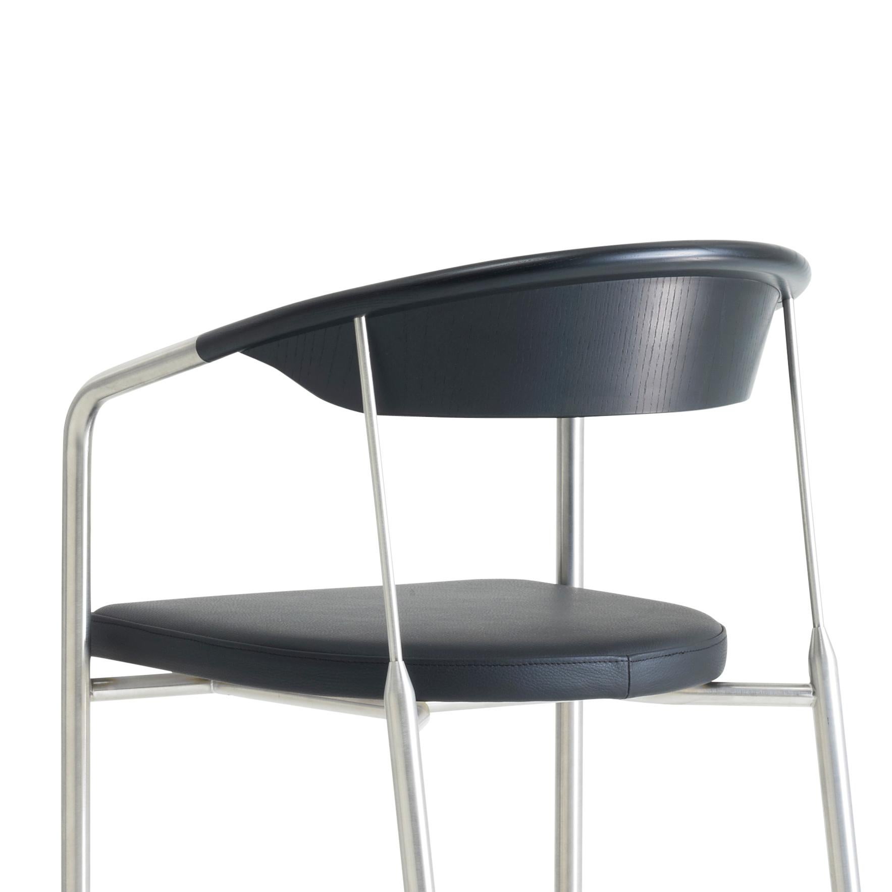The Chairman was designed by Henrik Tengler in 1990 for Onecollection and has since been produced exclusively in brushed stainless steel with a wooden backrest. The wooden backrest seamlessly conjoins with a stainless tube, which functions as an