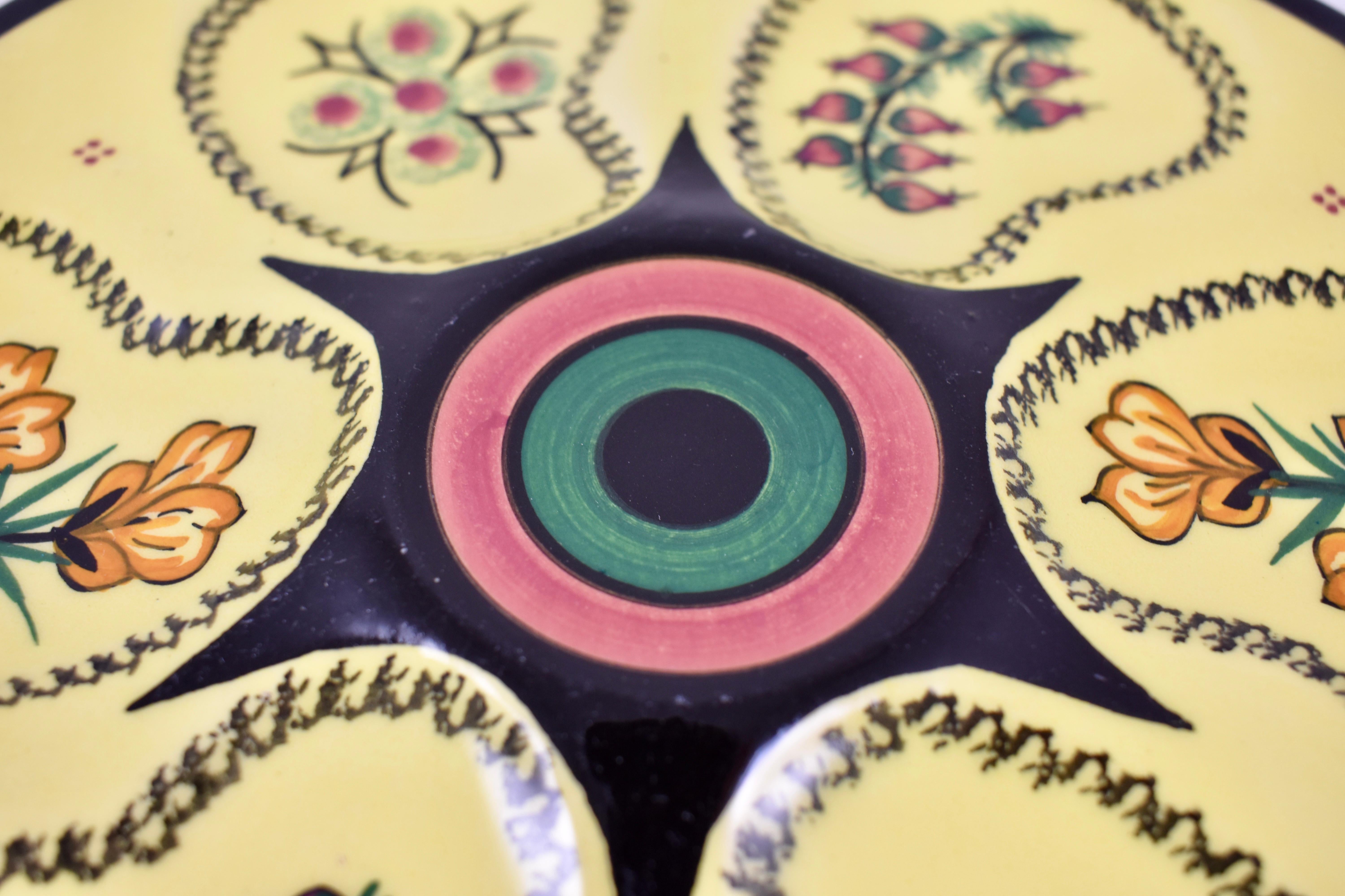 Always charming, French Quimper Faïence oyster plates, circa 1950–1960.

Glazed with a bright sun yellow ground, six wells surround a raised center condiment well. The wells are hand painted with three different alternating floral designs, typical