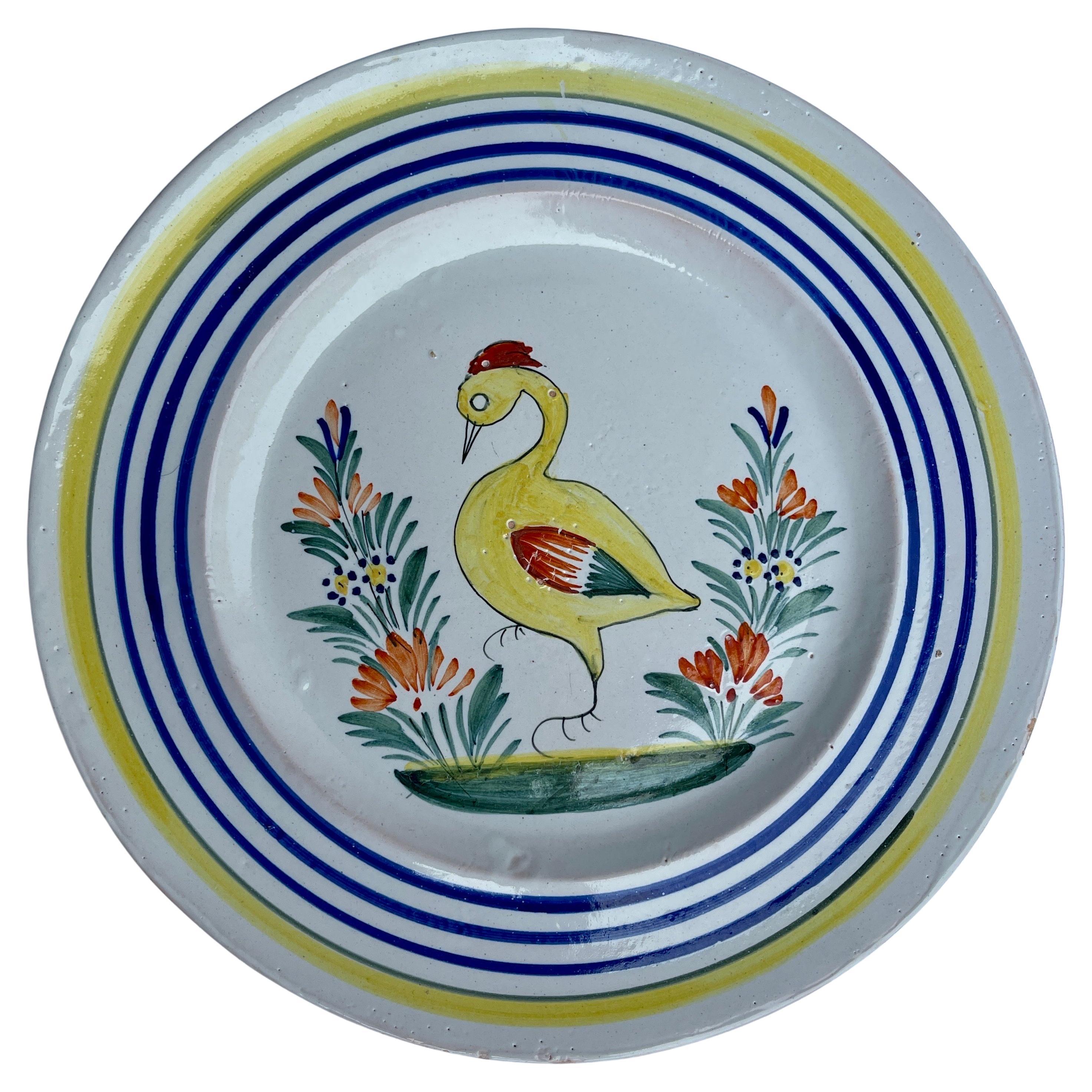 hand painted French Faience 1930s Quimper Duck Plate

Exceptional Quimper plate from France featuring a duck in the center. The rim of the piece is accentuated with a colorful border with yellow and blue lines. This rare and unusual illustration