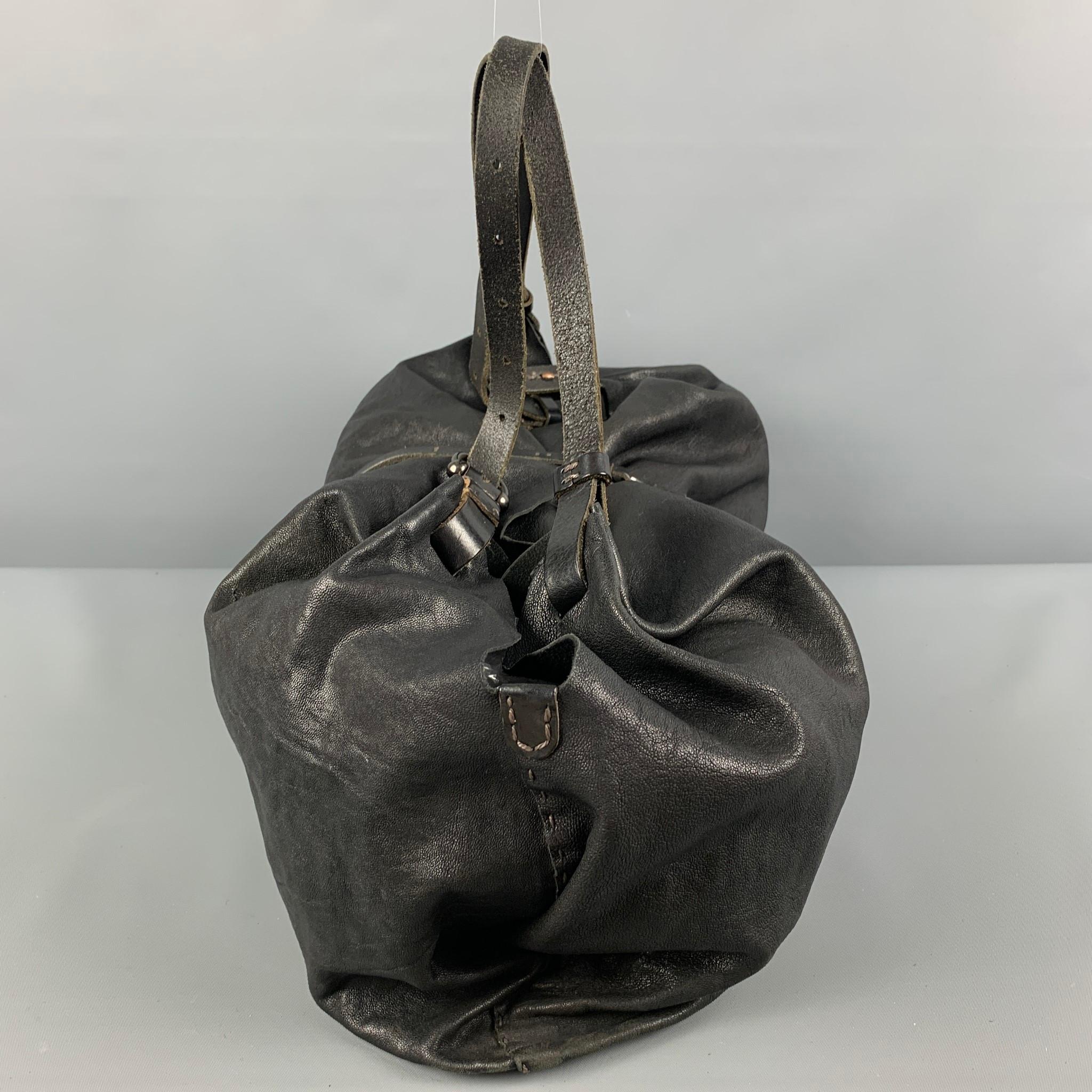 HENRY BEGUELIN bag comes in a black distressed leather featuring top handles, wallet attachment, silver ton hardware, and a front clasp closure. Includes tags & dust bag.

Very Good Pre-Owned Condition.

Measurements:

Length: 21 in.
Width: 10