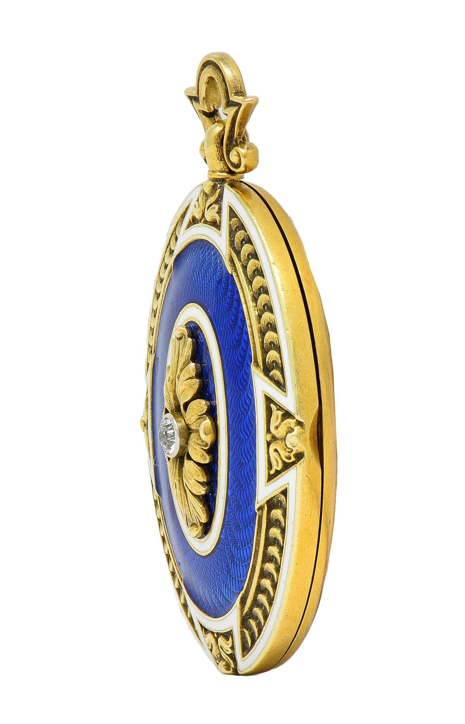 Designed as an oval-shaped locket pendant centering an old European cut diamond 
Weighing approximately 0.08 carat and eye clean and bright - bezel set
With a dimensional foliate motif appliqué surround atop guilloche enamel
Transparent royal blue