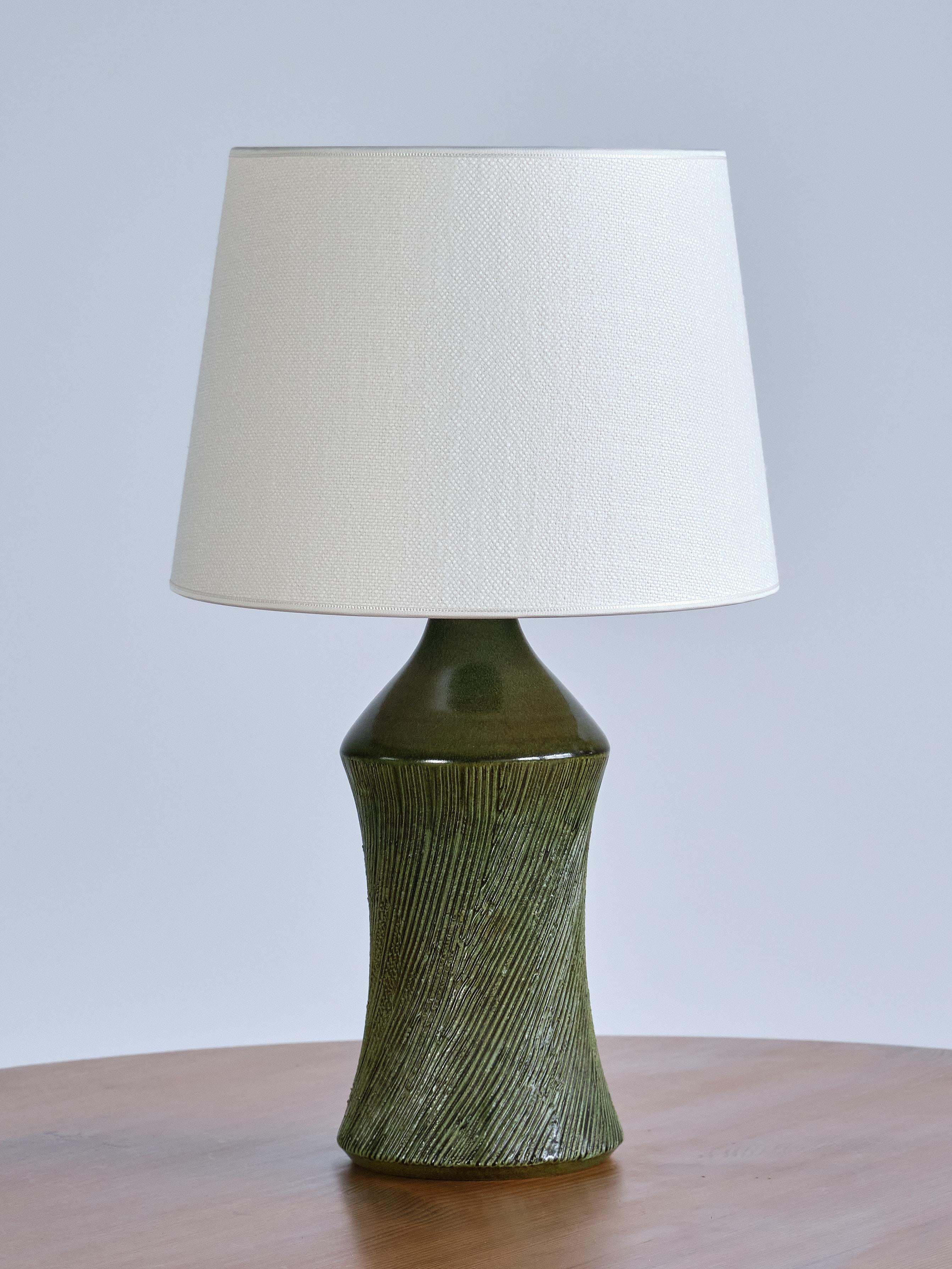This striking stoneware table lamp was designed by Henry Brandi, and produced by his own firm, Brandi Vejbystrand, Sweden, 1960s. Signed 'Brandi' and labeled underneath.

The base is executed in glazed stoneware in a beautiful shade of forest green.