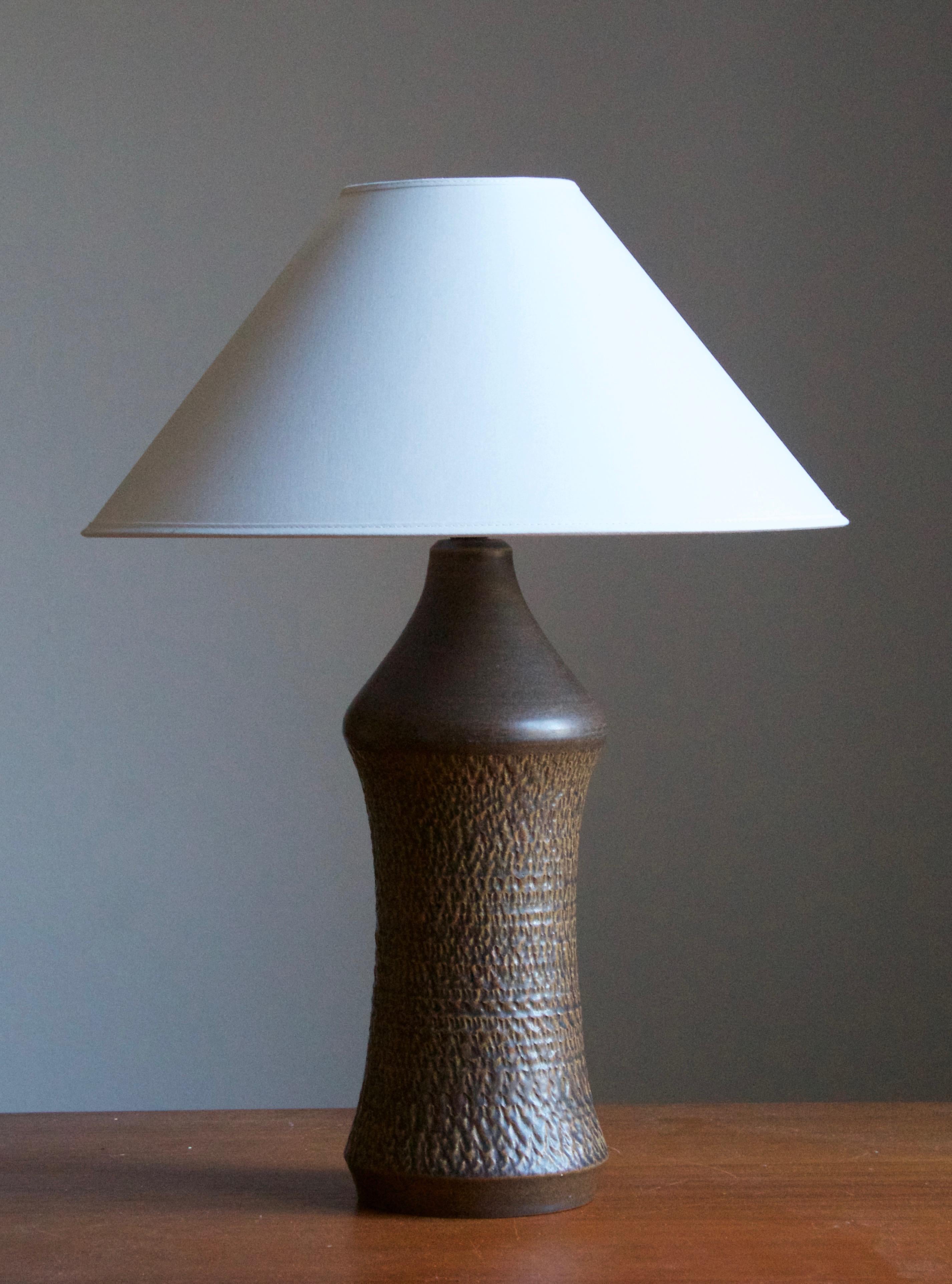 A sizable organic stoneware table lamp designed by Henry Brandi, and produced by his own firm, Brandi Vejbystrand, Sweden, 1960s. Marked and labeled. 

Sold without lampshade. Stated dimensions exclude lamsphade.

Other lighting designers of the
