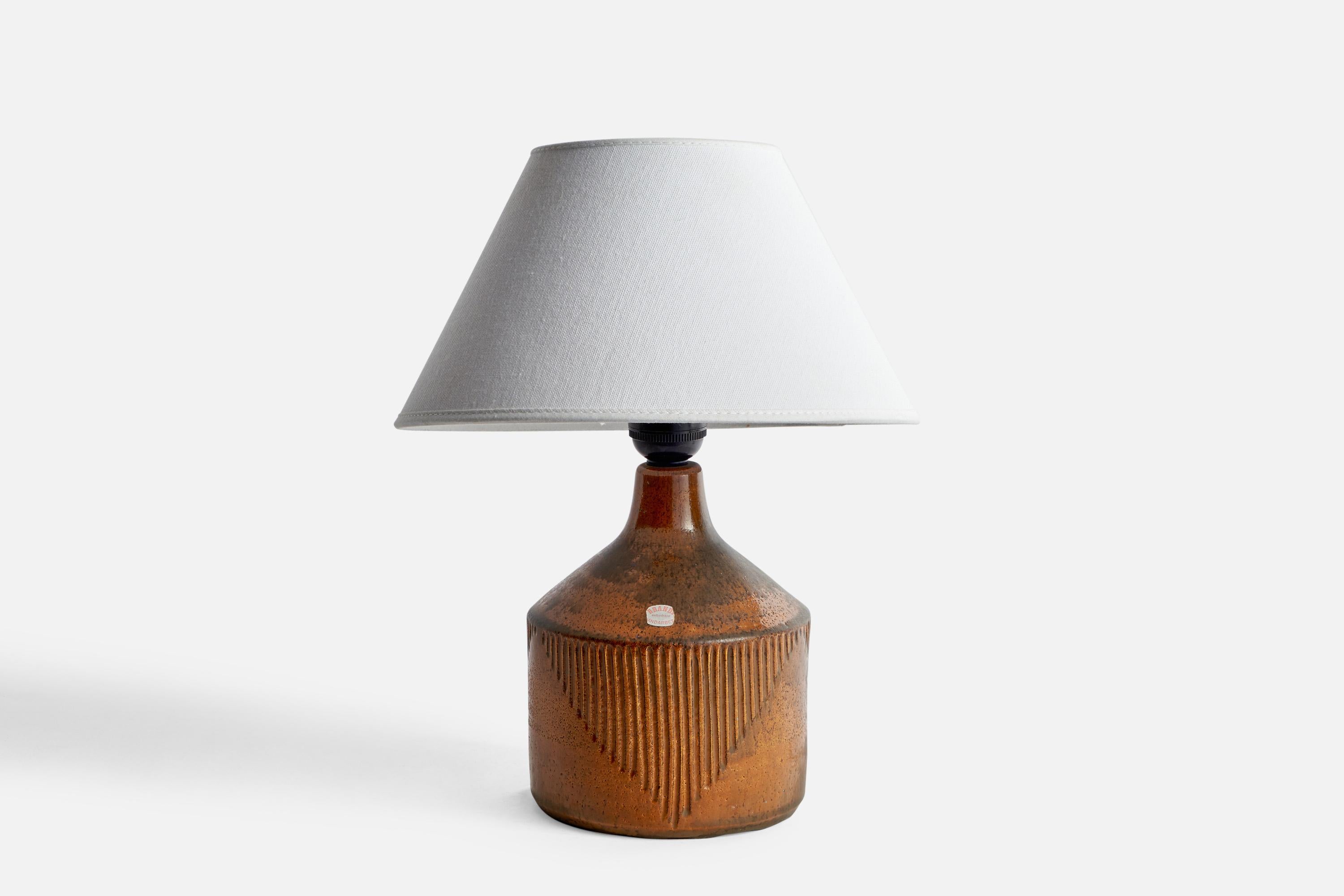 A brown-glazed incised table lamp designed and produced in Sweden, 1960s.

Dimensions of Lamp (inches): 9” H x 5.45” Diameter
Dimensions of Shade (inches): 4.5” Top Diameter x 10” Bottom Diameter x 5.25” H
Dimensions of Lamp with Shade (inches):