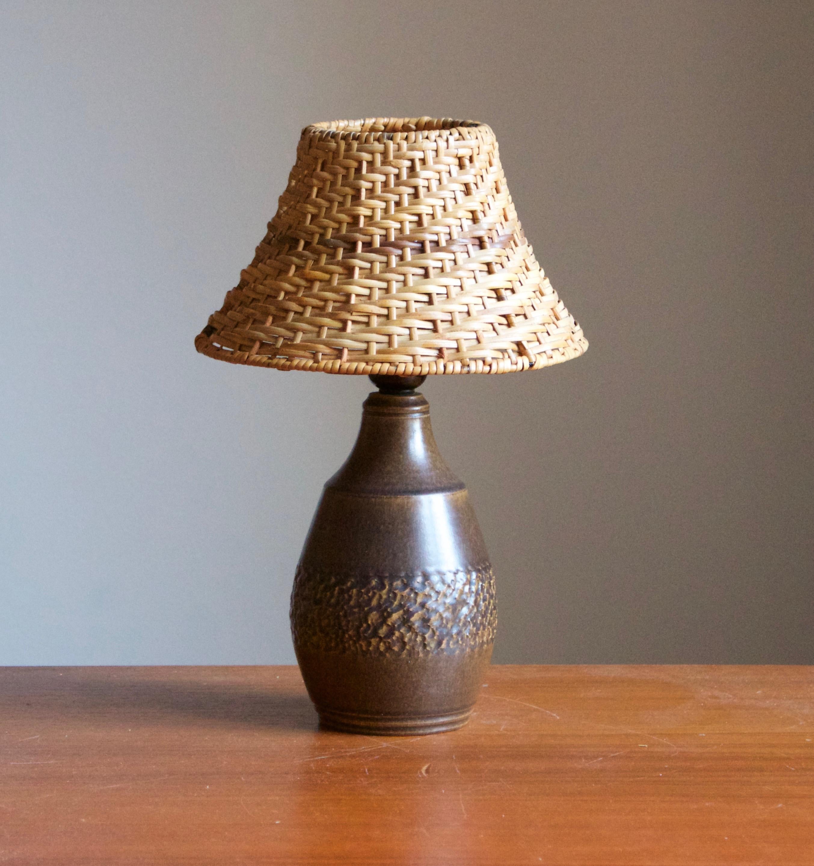 A sizable organic stoneware table lamp designed by Henry Brandi, and produced by his own firm, Brandi Vejbystrand, Sweden, 1960s. Marked and labeled. 

Stated dimensions exclude lampshade. Height includes socket. Assorted vintage rattan lampshade