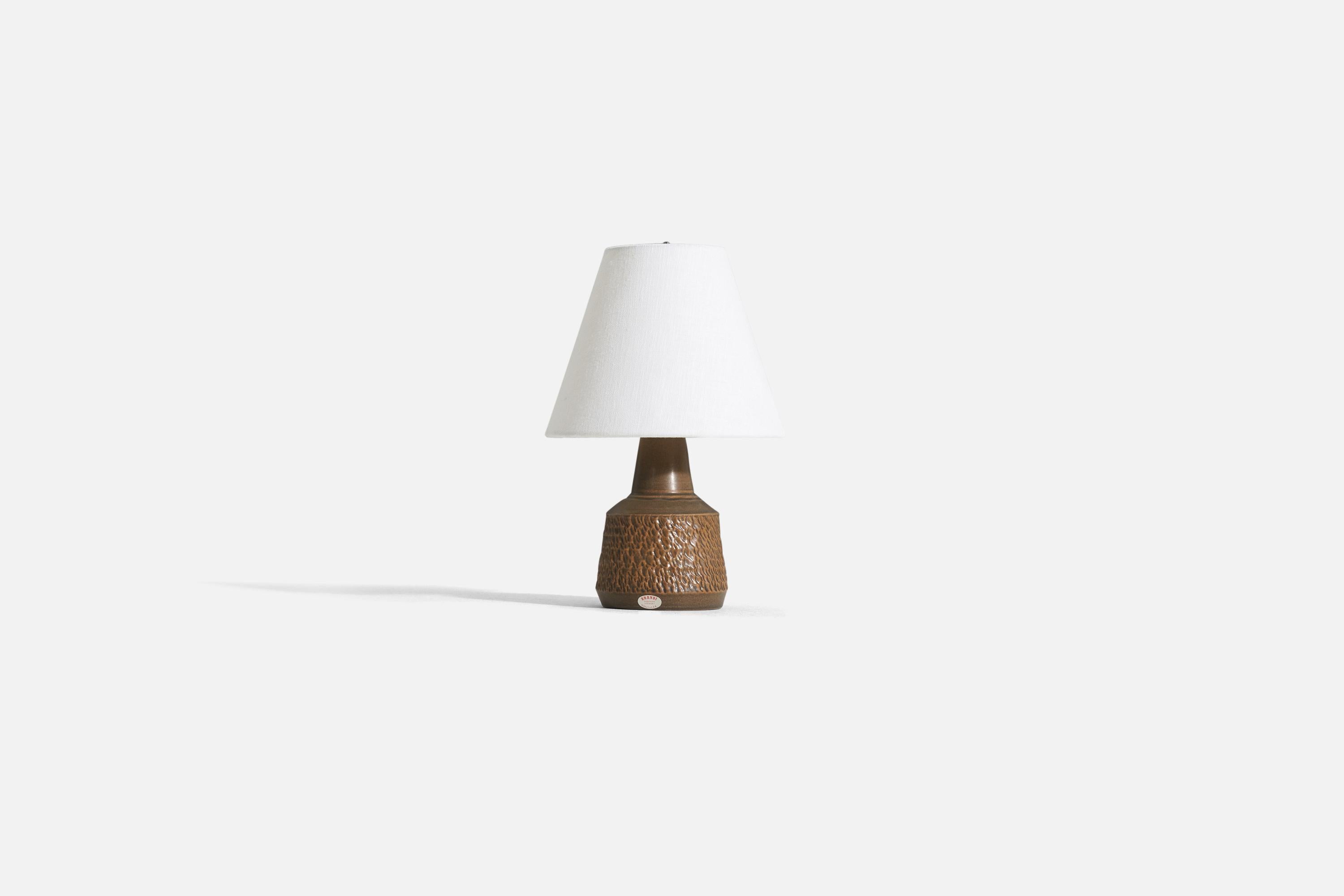 A brown glazed stoneware table lamp designed by Henry Brandi and produced by his own firm, Brandi Vejbystrand, Sweden, 1960s. Marked and labeled. 

Sold without lampshade. 

Dimensions of lamp (inches) : 8.5 x 4.5 x 4.5 (H x W x D).
Dimensions