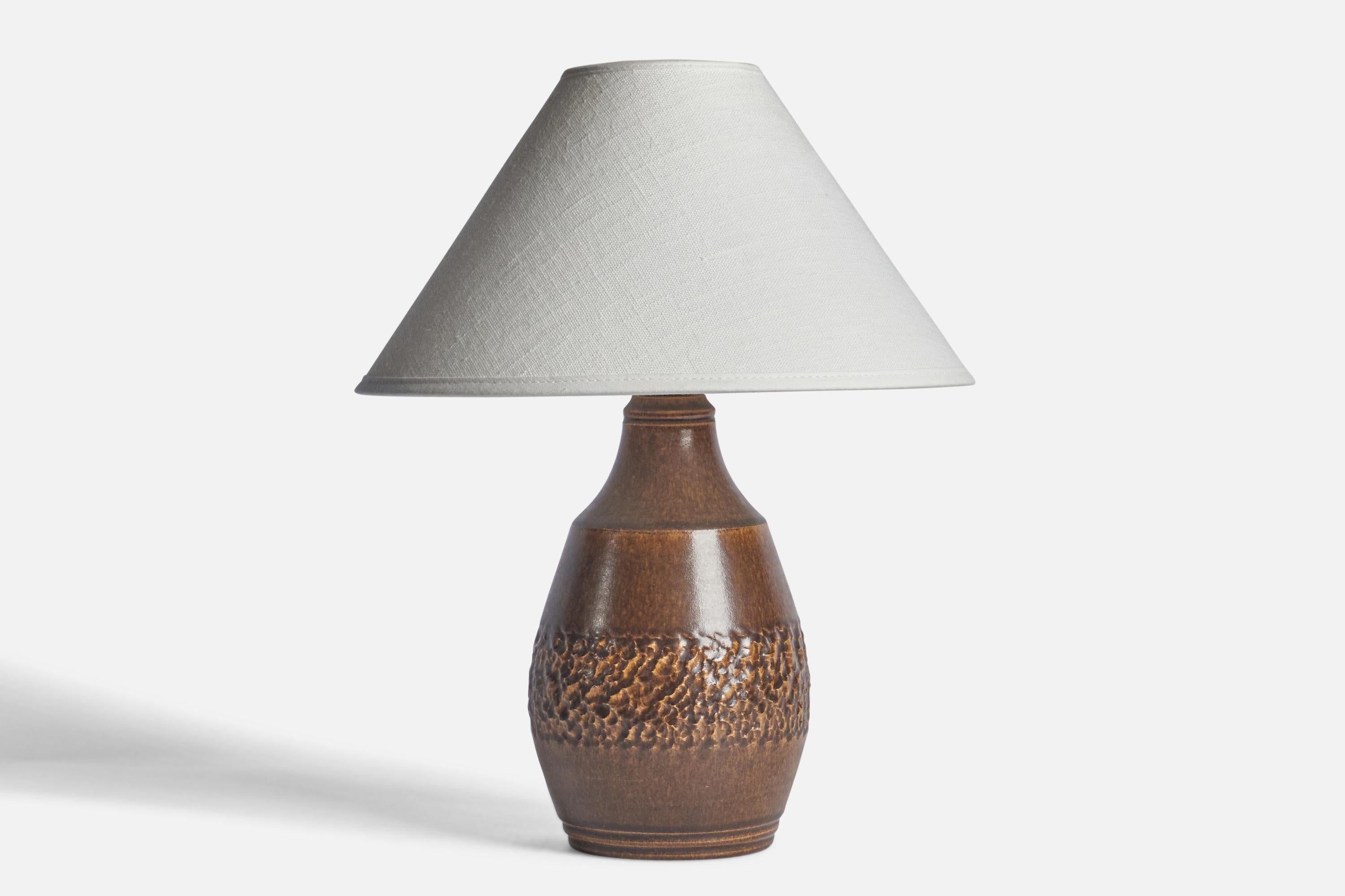 A brown-glazed and incised stoneware table lamp designed and produced by Henry Brandi, Sweden, c. 1960s.

Dimensions of Lamp (inches): 9.75