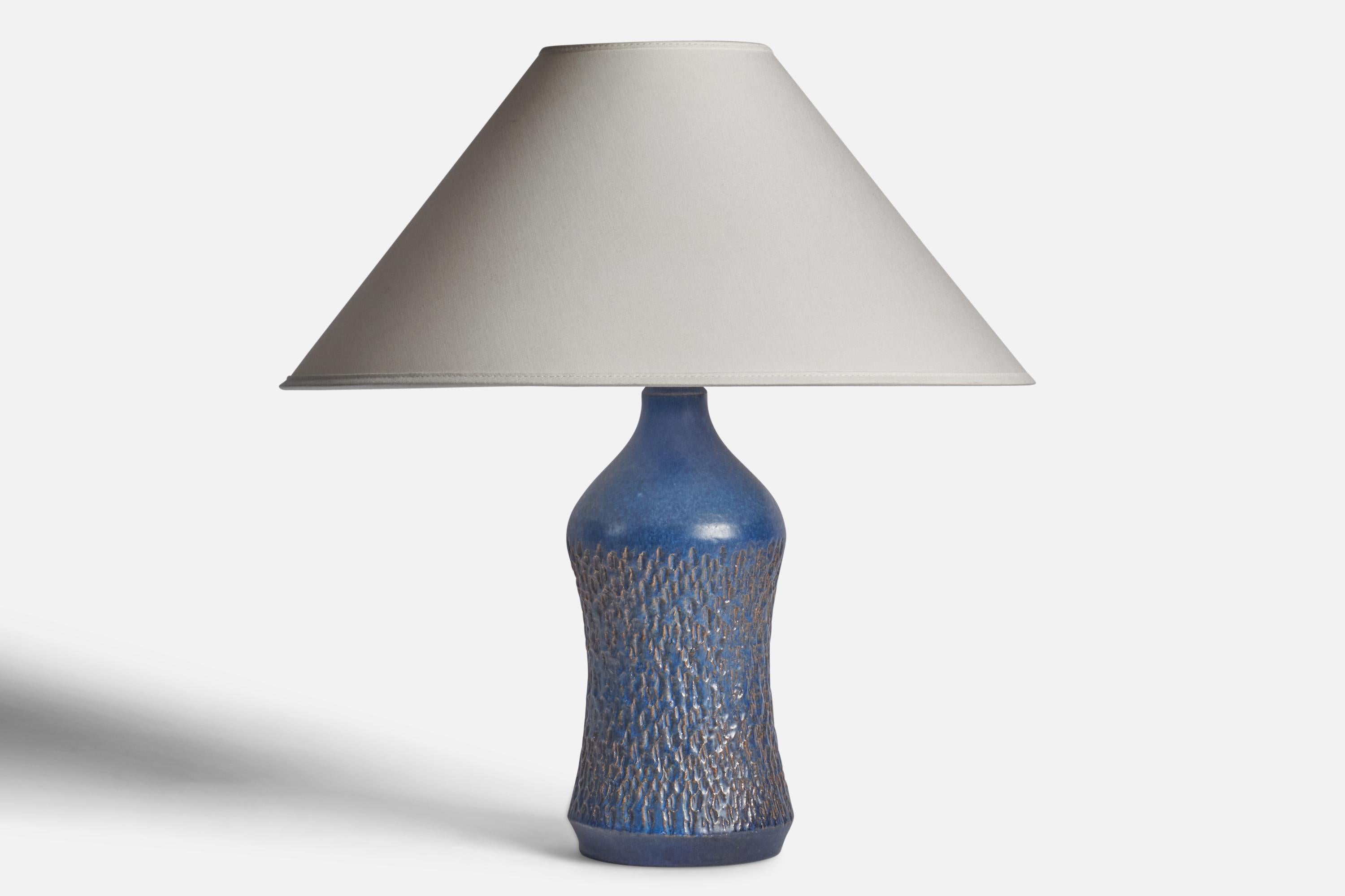 A blue-glazed incised stoneware table lamp designed and produced by Henry Brandi, Sweden, 1960s.

Dimensions of Lamp (inches): 12.5” H x 4.5” Diameter
Dimensions of Shade (inches): 4.5” Top Diameter x 16” Bottom Diameter x 7.25” H
Dimensions of Lamp