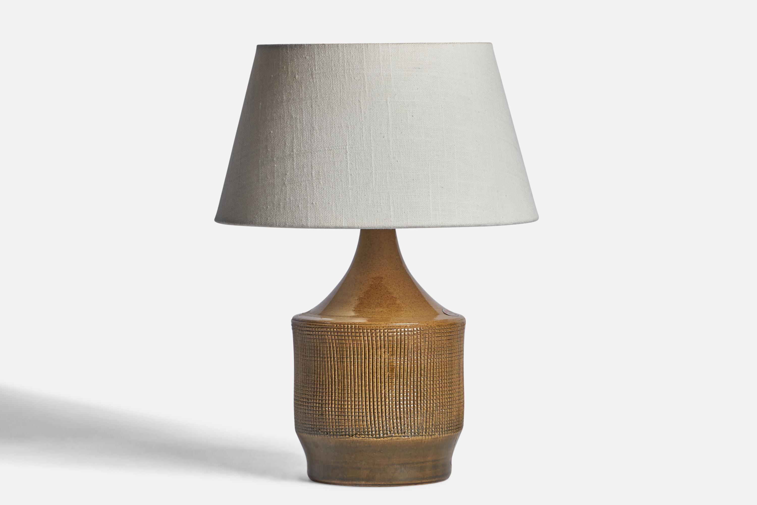 A beige stoneware table lamp designed and produced by Henry Brandi, Vejbystrand, Sweden, c. 1960s.

Dimensions of Lamp (inches): 10.15” H x 5.25” Diameter
Dimensions of Shade (inches): 7” Top Diameter x 10” Bottom Diameter x 5.5” H 
Dimensions of