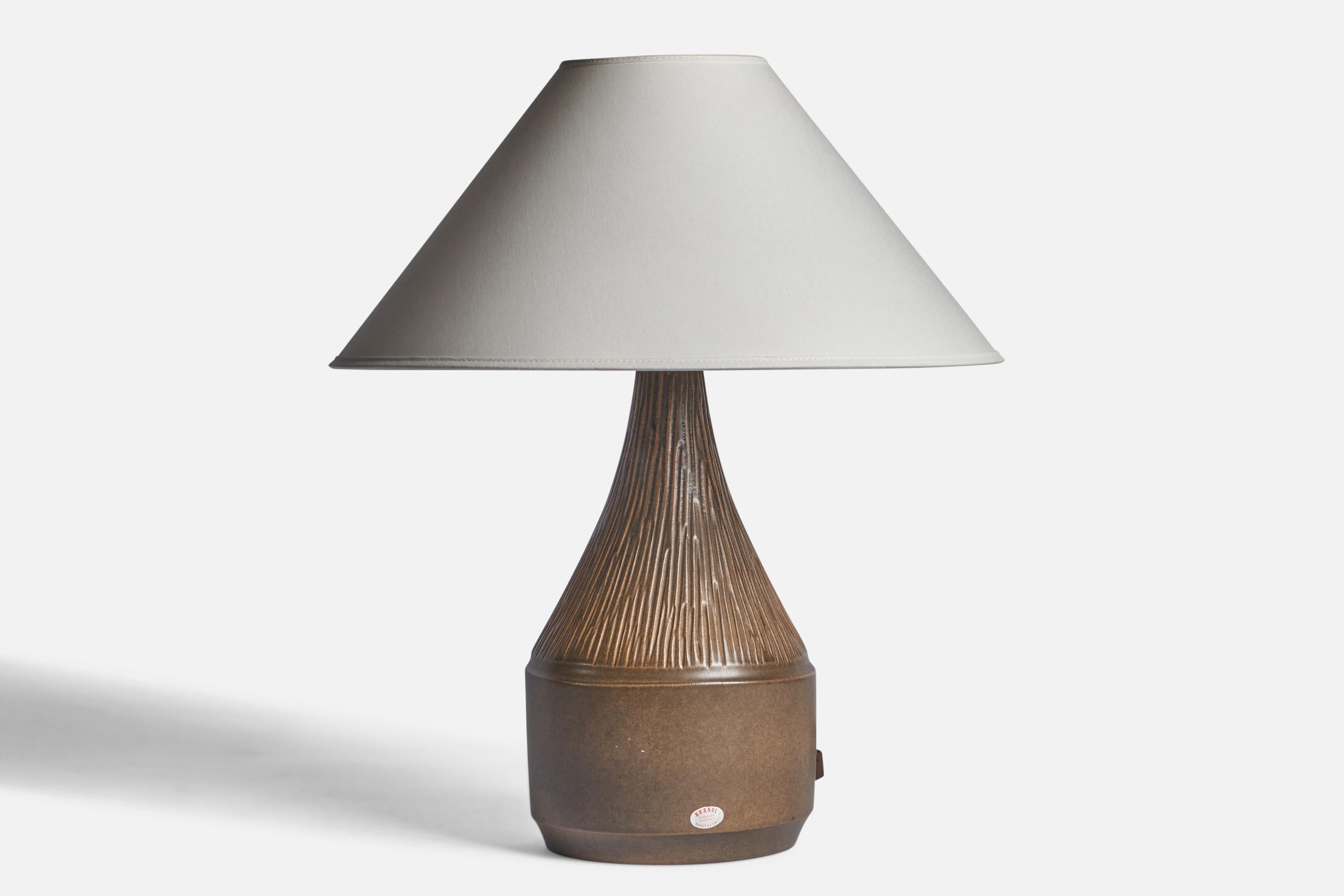 A brown-glazed stoneware table lamp designed and produced by Henry Brandi, Vejbystrand, Sweden, c. 1960s.

Dimensions of Lamp (inches): 14.5” H x 6.75” Diameter
Dimensions of Shade (inches): 4.5” Top Diameter x 16” Bottom Diameter x 7.25”