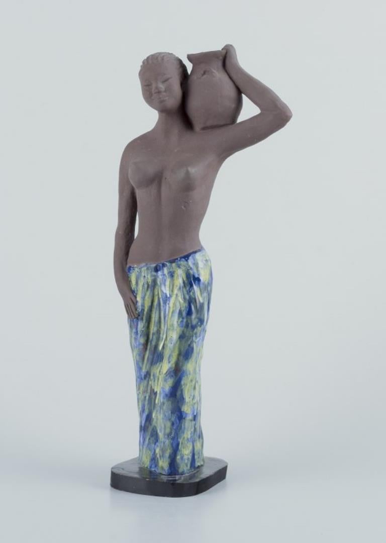 Bengt Wall, Suecia. 
Estatuilla alta de una niña de Bali en cerámica cruda y esmaltada.
1950s. 
En excelente estado, con mínimos signos de uso.
Firmado.
Medidas: Alto 32,0 cm. x Ancho 12,0 cm.