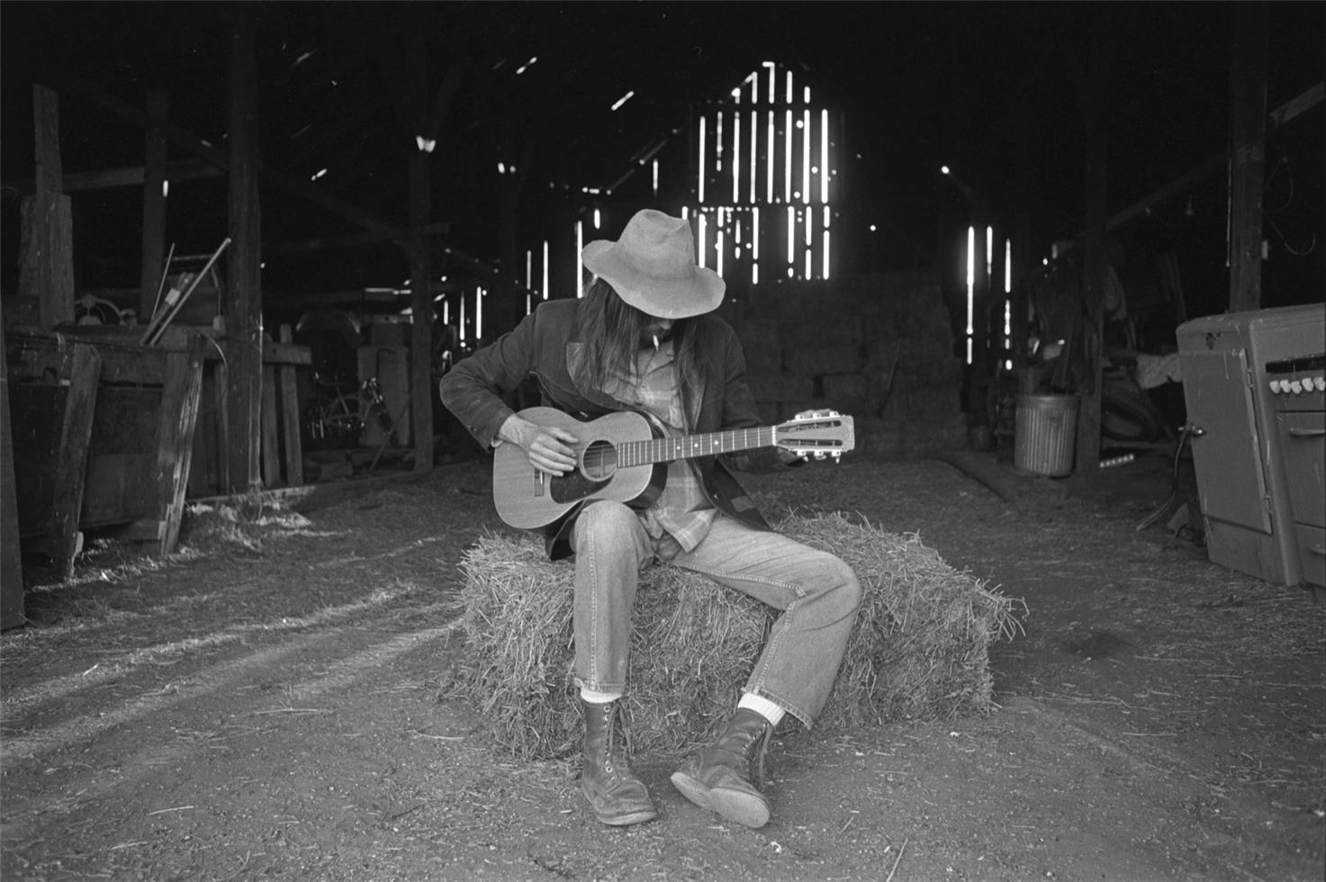 Henry Diltz Black and White Photograph – Neil Young, Scheune auf der Broken Arrow Ranch, 1971