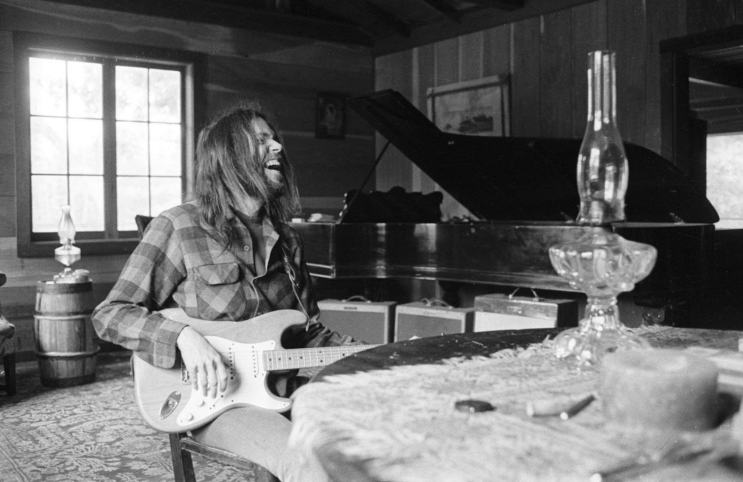 Henry Diltz Black and White Photograph – Neil Young, Lachend, Broken Arrow Ranch, Half Moon Bay, CA 1971