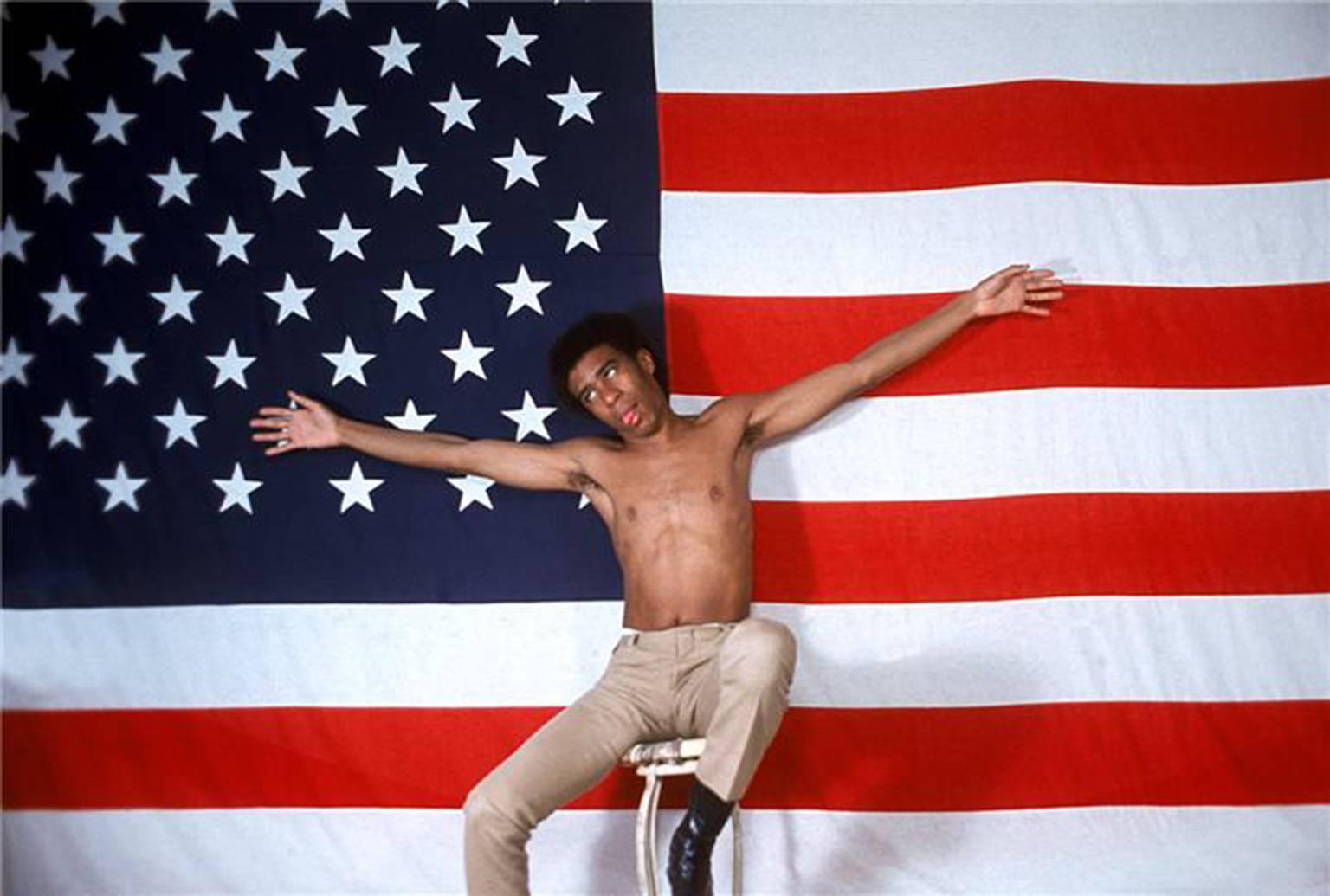 Color Photograph Henry Diltz - Richard Pryor, drapeau américain, 1968