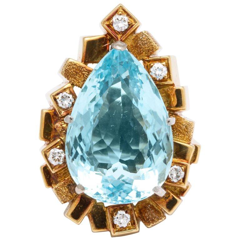 An exceptional design 18k mounting of a large pear shaped faceted Aquamarine with Diamonds set in gold cubes with ridges surrounding the Aquamarine. This rare piece is hand made and signed Henry Dunay fr.