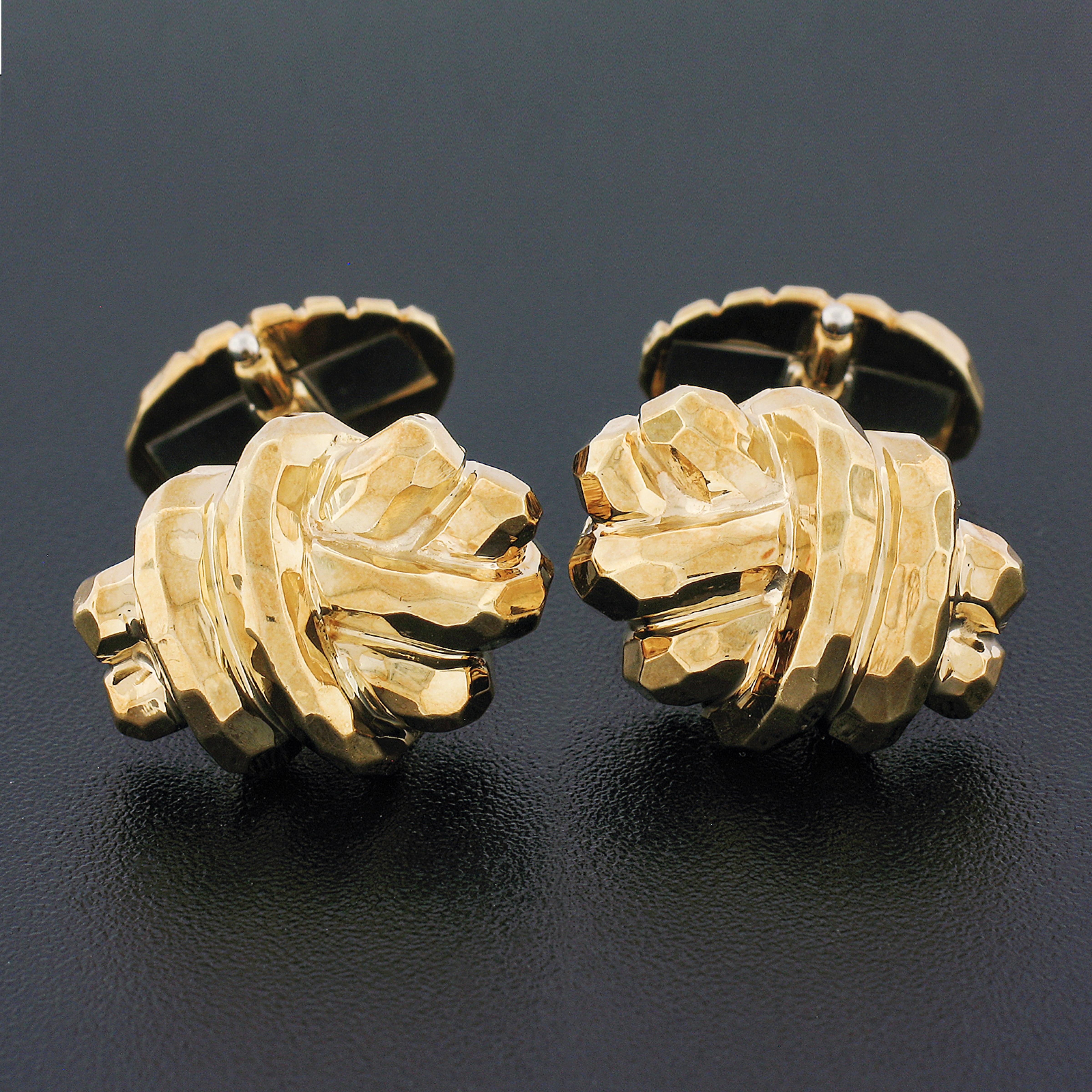 Here we have a classy and refined pair of designer cuff links crafted from solid 18k yellow gold by Henry Dunay. Each of the cuff links is an infinity love knot design that displays a nice hammered finish throughout. This sharp pair of cuff links