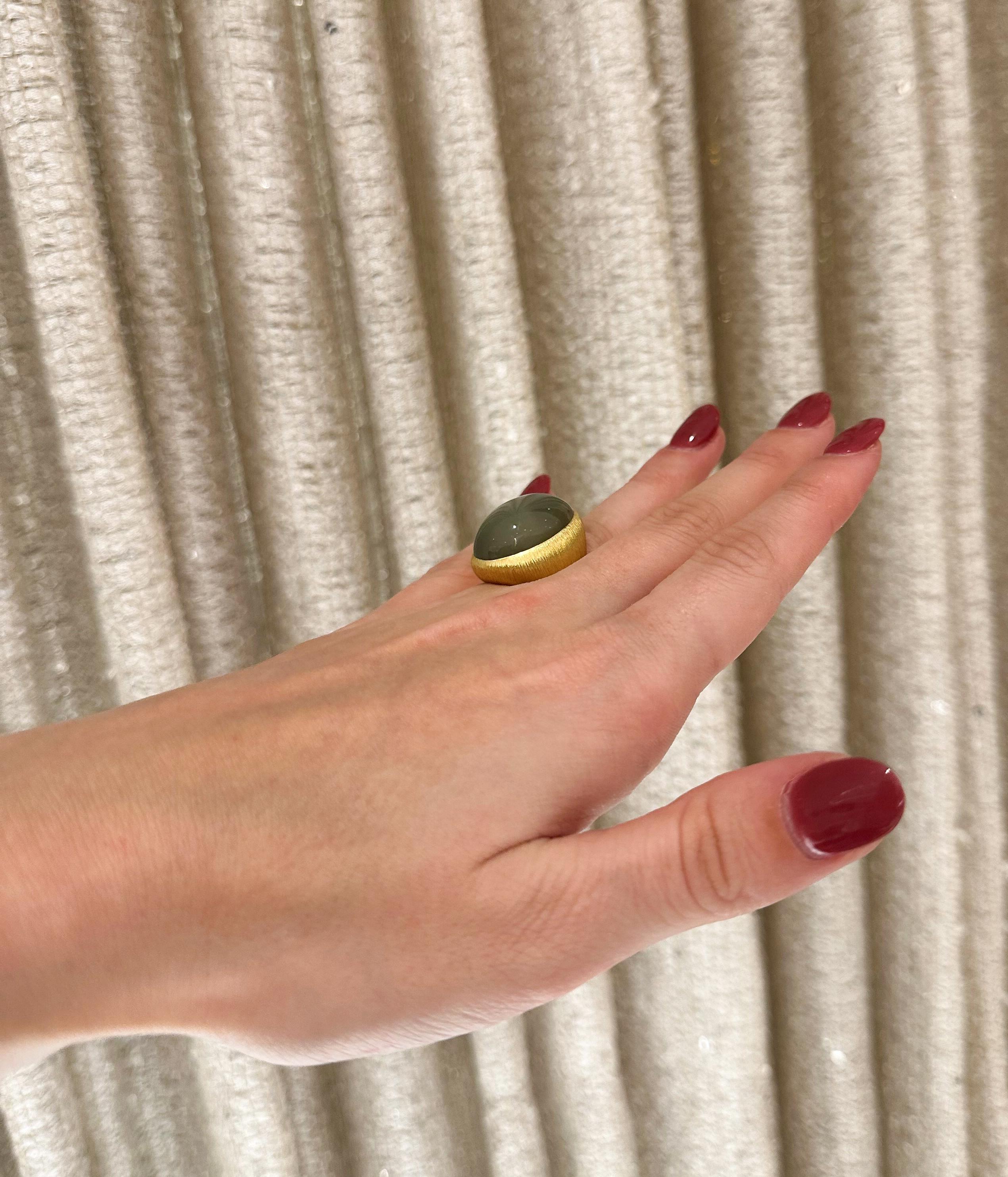 Der 18-karätige Gelbgoldring des Designers Henry Dunay aus der Eiseman Estate Jewelry Collection aus den 1980er Jahren ist mit einem hellgrünen Mondstein-Cabochon von etwa 18,94 Karat besetzt. Der Ring hat eine strukturierte gebürstete Oberfläche